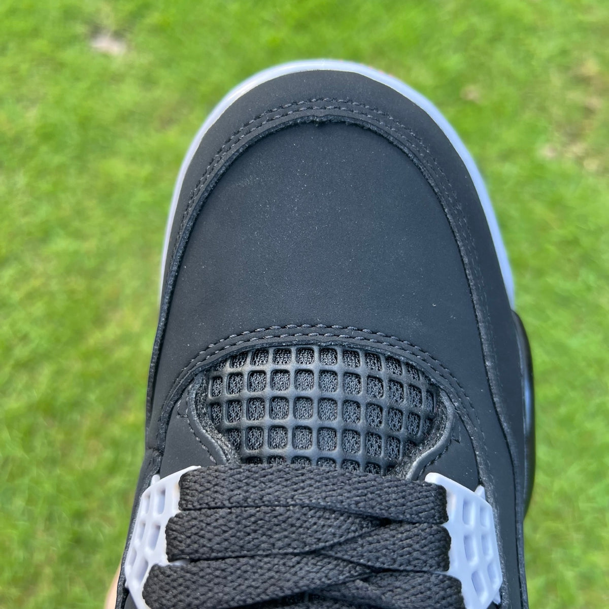 Nike Air Jordan 4 Retro OG Bred sneakers featuring black and red leather with Jumpman logo and mesh details.