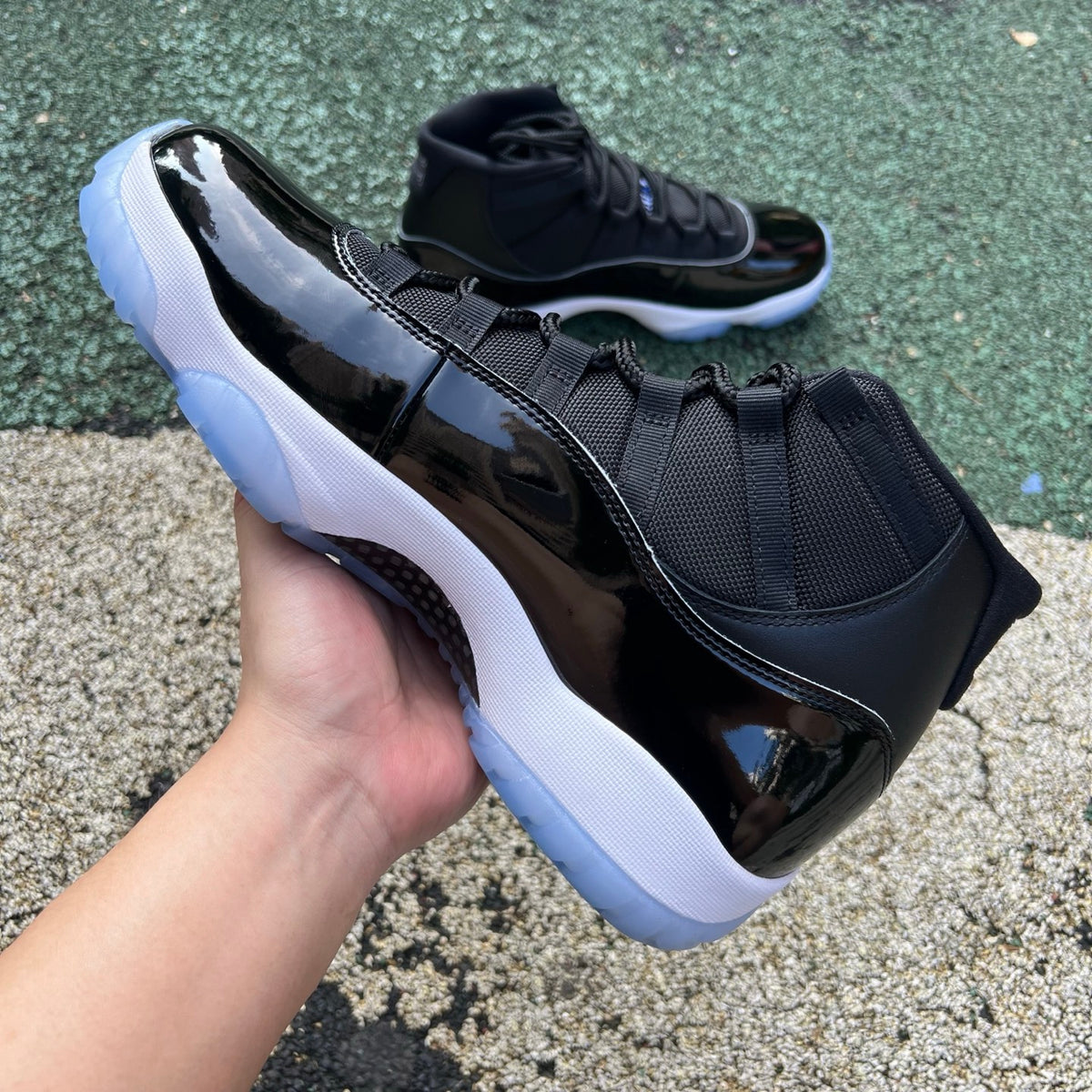 Nike Air Jordan 11 Retro Space Jam sneakers in black and blue with patent leather accents, front view.