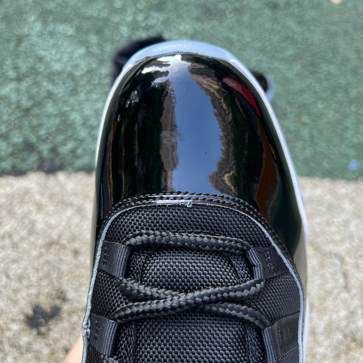 Nike Air Jordan 11 Retro Space Jam (2026) sneakers featuring black patent leather, white mesh, and icy blue accents.