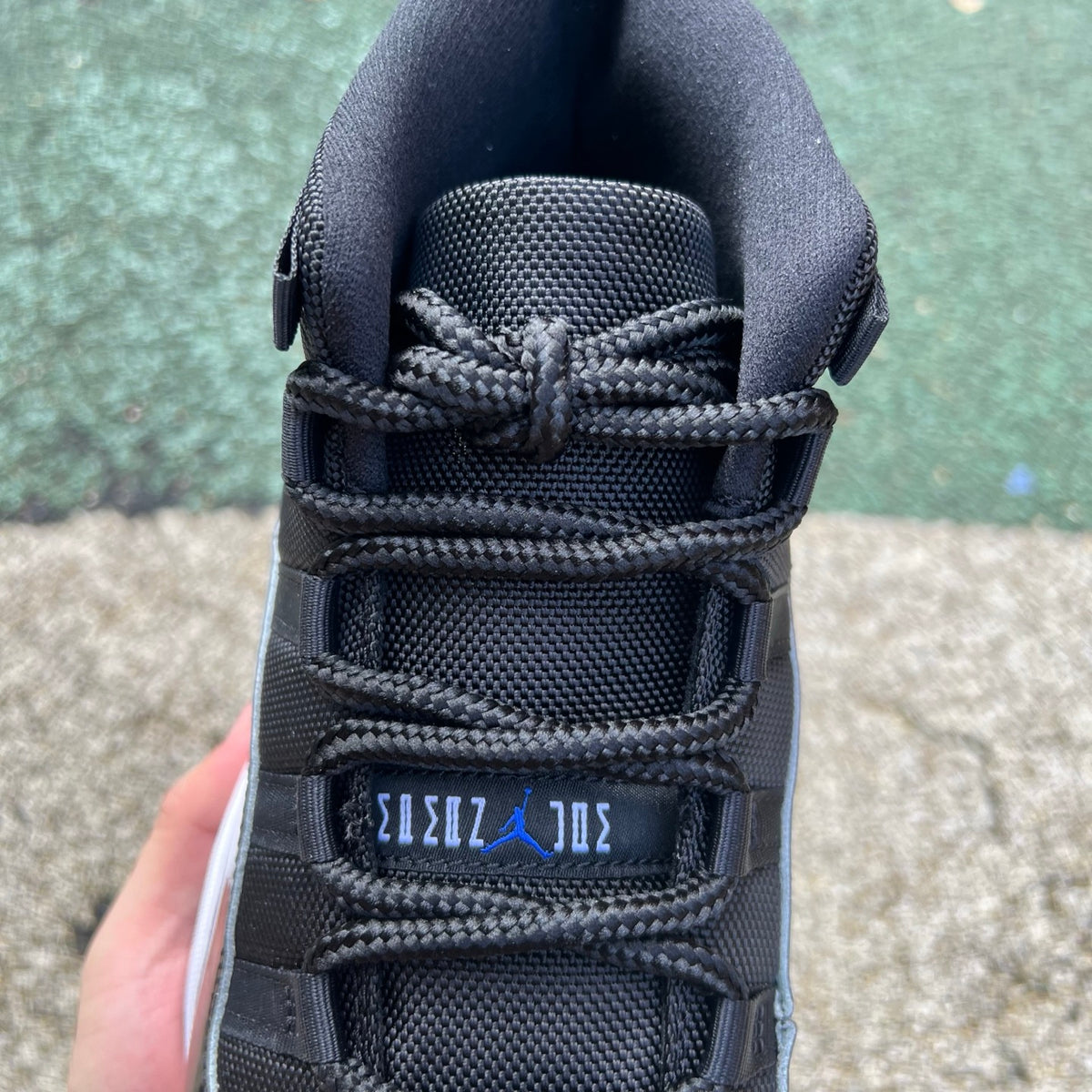 Nike Air Jordan 11 Retro Space Jam sneakers in black patent leather with icy blue soles, detailed with Jumpman logos.