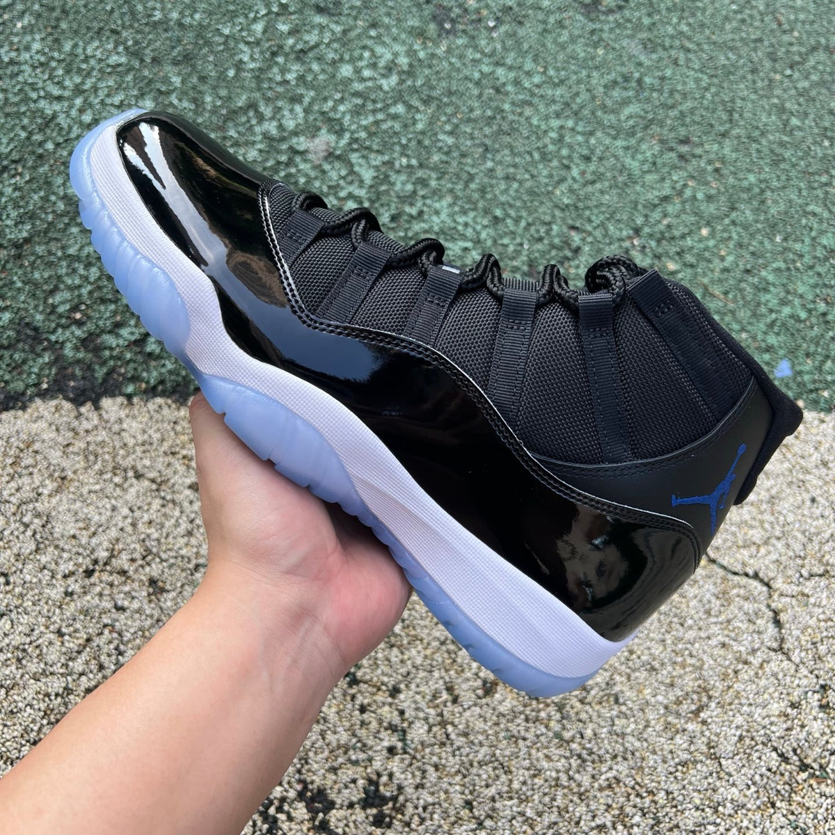 Nike Air Jordan 11 Retro Space Jam sneaker in black and blue with patent leather and white accents, designed for basketball and style.