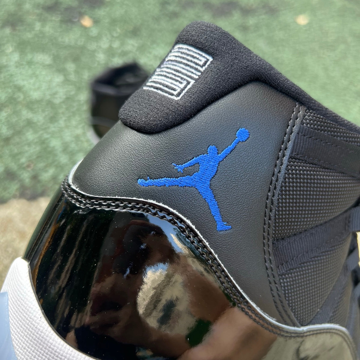 Nike Air Jordan 11 Retro Space Jam basketball shoes in black and patent leather with icy blue outsole, designed by Nike x Jordan.