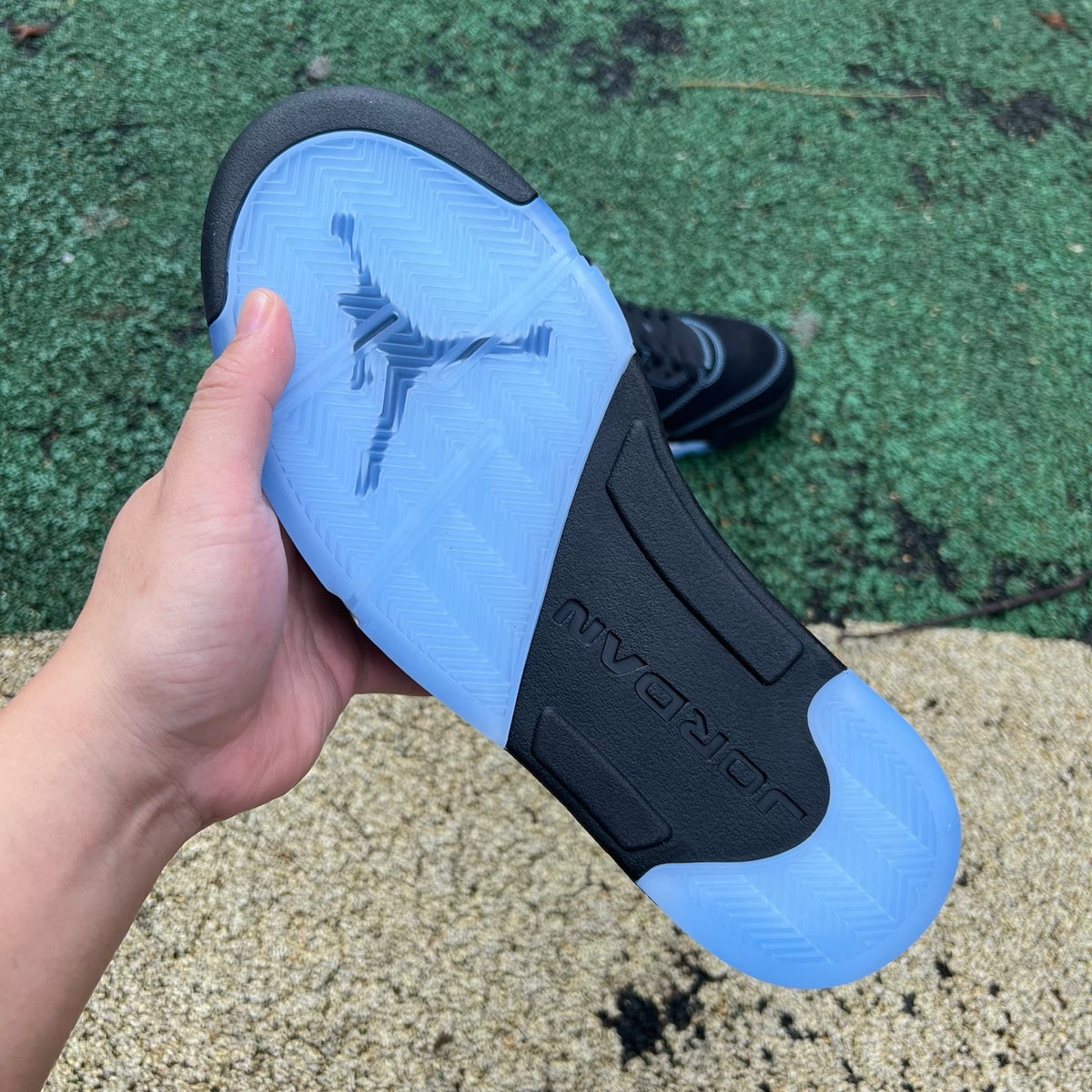 Nike Air Jordan 5 Retro sneakers in black and university blue, featuring a sleek design and visible Air units on the sole.