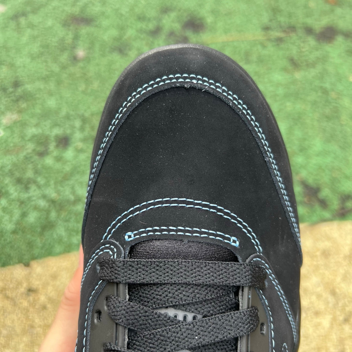 Nike Air Jordan 5 Retro sneakers in black with university blue accents, featuring a classic design and signature Jordan brand details.