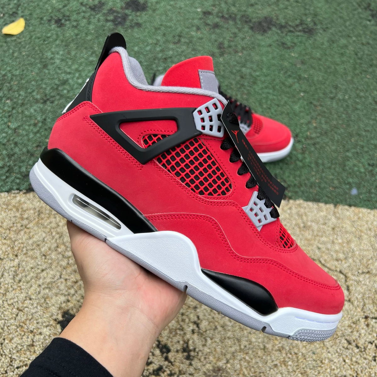 Nike Air Jordan 4 Retro Toro Bravo sneakers in red and black with white accents, featuring lightweight design and signature Jordan branding.