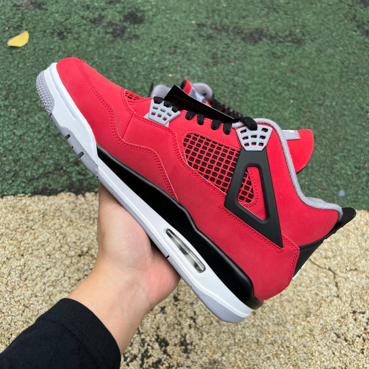 Nike Air Jordan 4 Retro Toro Bravo sneakers in red and black with white accents, showcasing the iconic design and details.