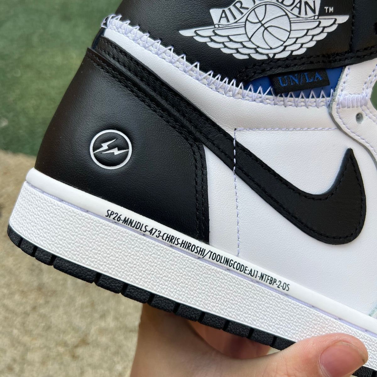 Nike Air Jordan 1 Retro High OG SP Fragment x Union LA sneakers in white and black, displayed from a side angle.