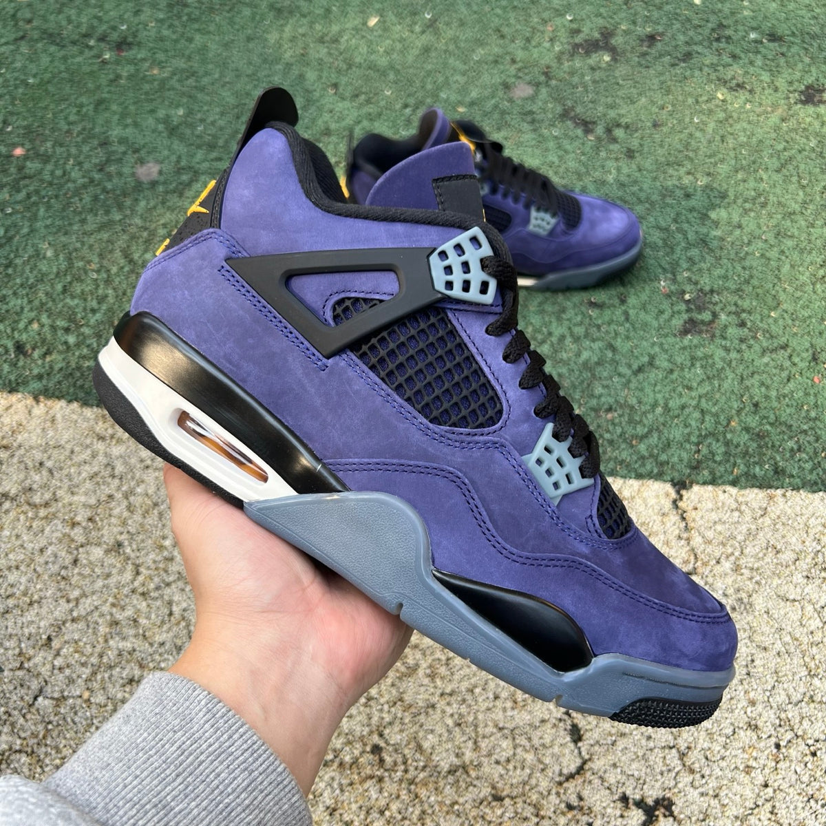 Nike Air Jordan 4 Retro Lakers sneakers in purple and yellow with white accents, featuring classic Air Jordan design details.