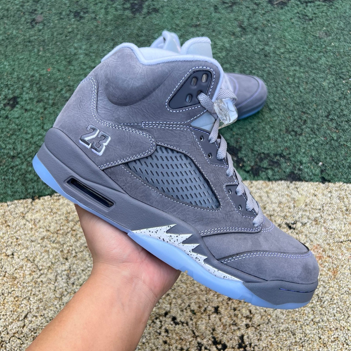 Nike Air Jordan 5 Retro Wolf Grey sneakers, featuring grey suede and white accents, displayed from a side view.