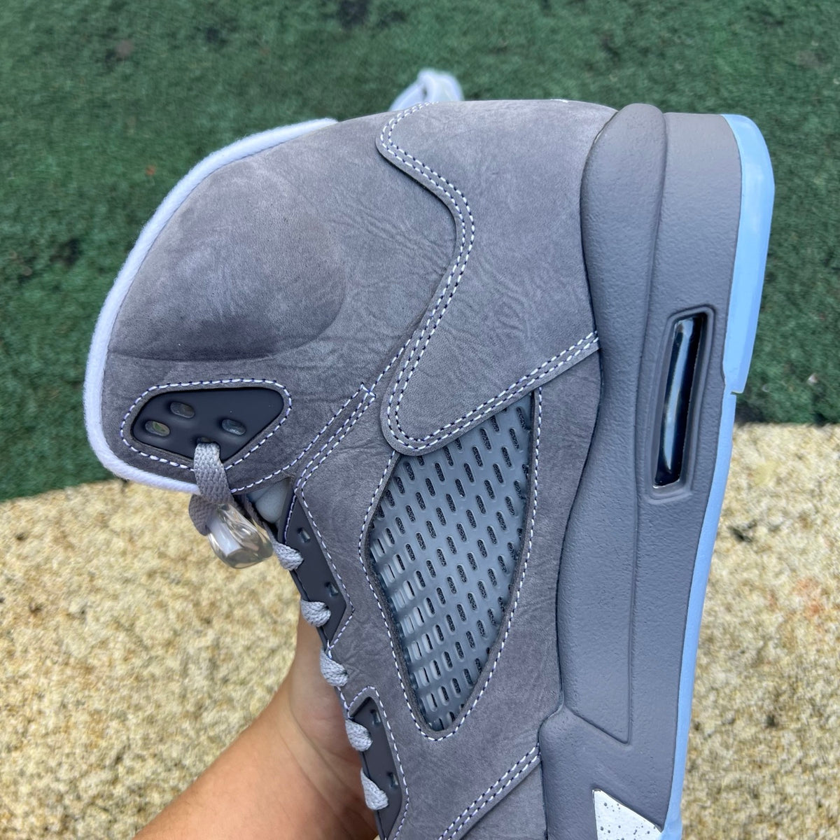 Nike Air Jordan 5 Retro Wolf Grey sneakers featuring grey leather and mesh upper with black accents and Nike branding.