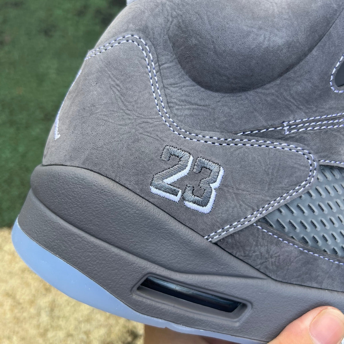 Nike Air Jordan 5 Retro Wolf Grey sneakers featuring grey leather and mesh upper with black accents and a white sole.