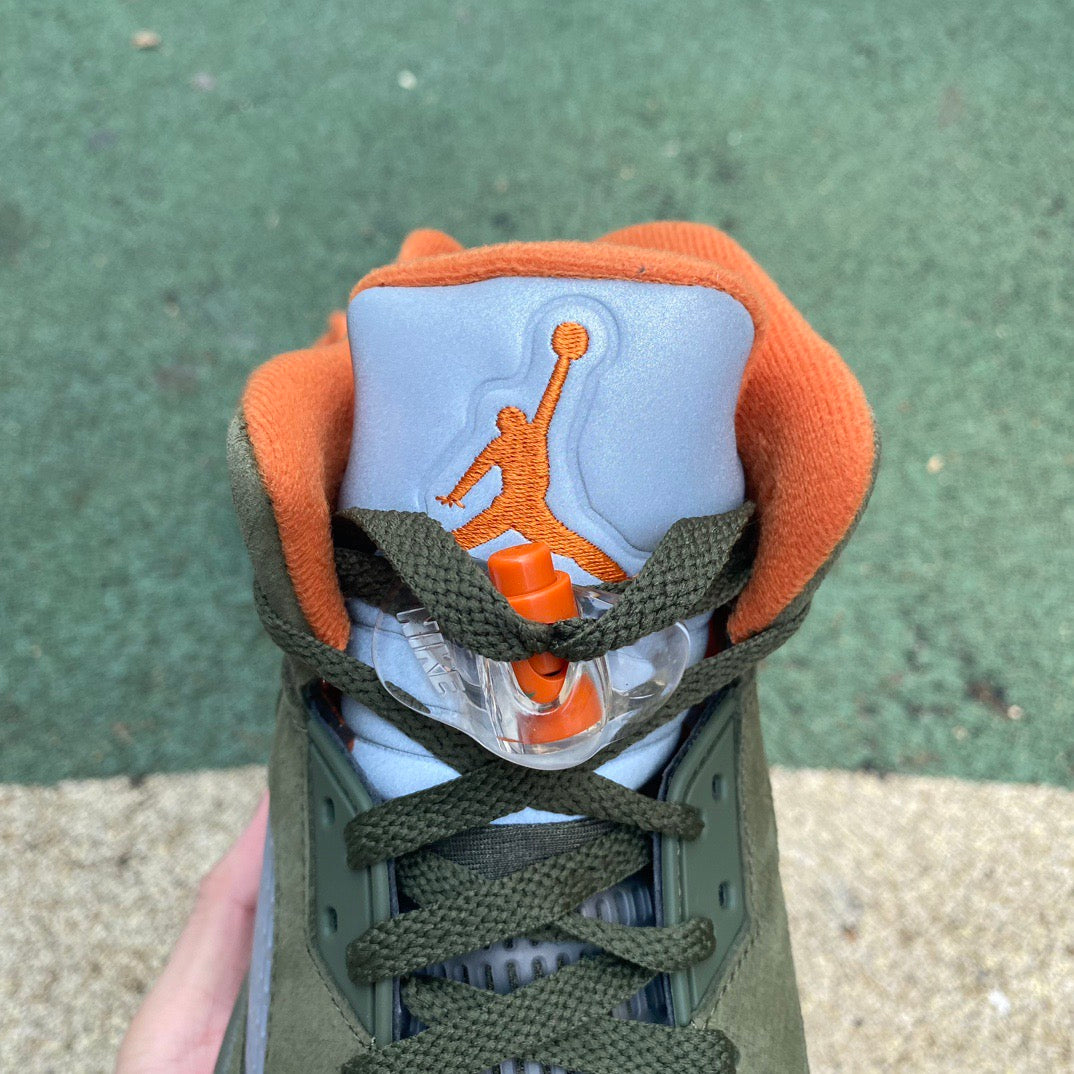 Nike Air Jordan 5 Retro Olive sneakers in a close-up view, showcasing the olive green colorway and distinctive design details.