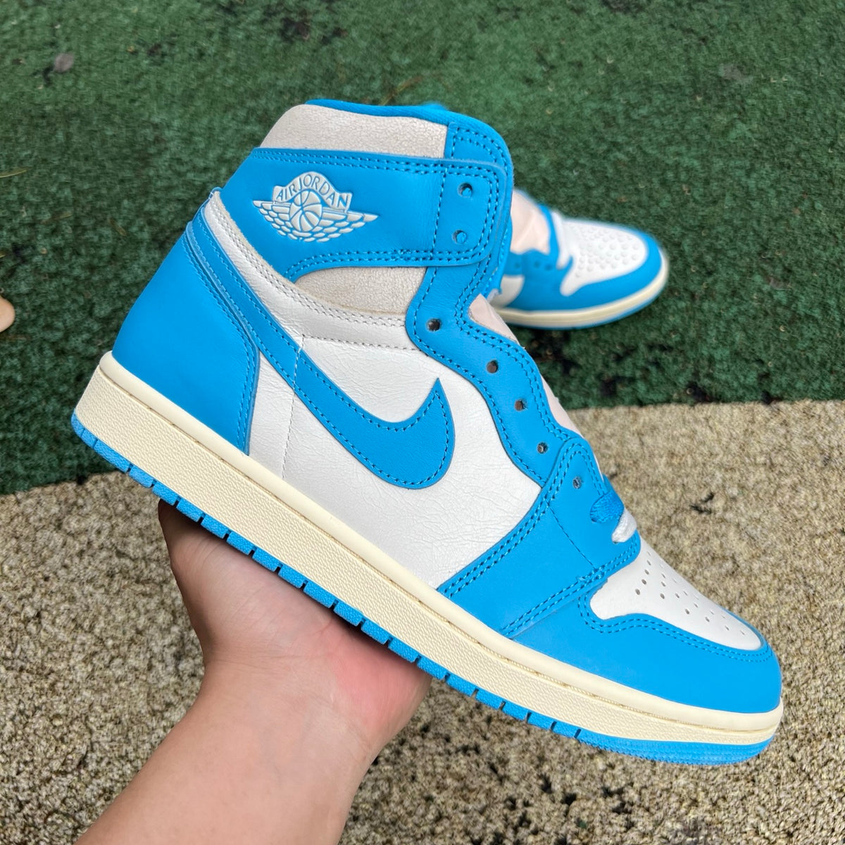 Nike Air Jordan 1 Retro High OG UNC Reimagined sneaker in blue and white leather with Nike swoosh and high-top design.