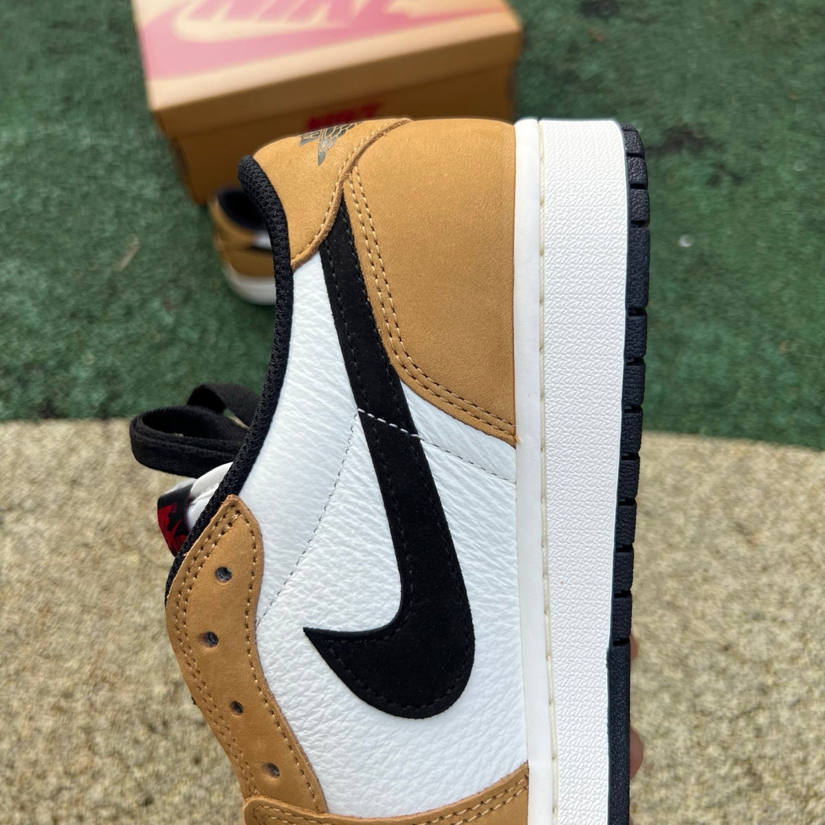 Nike Air Jordan 1 Low OG Rookie of the Year sneakers in white and black with Nike and Jordan branding, close-up side view.