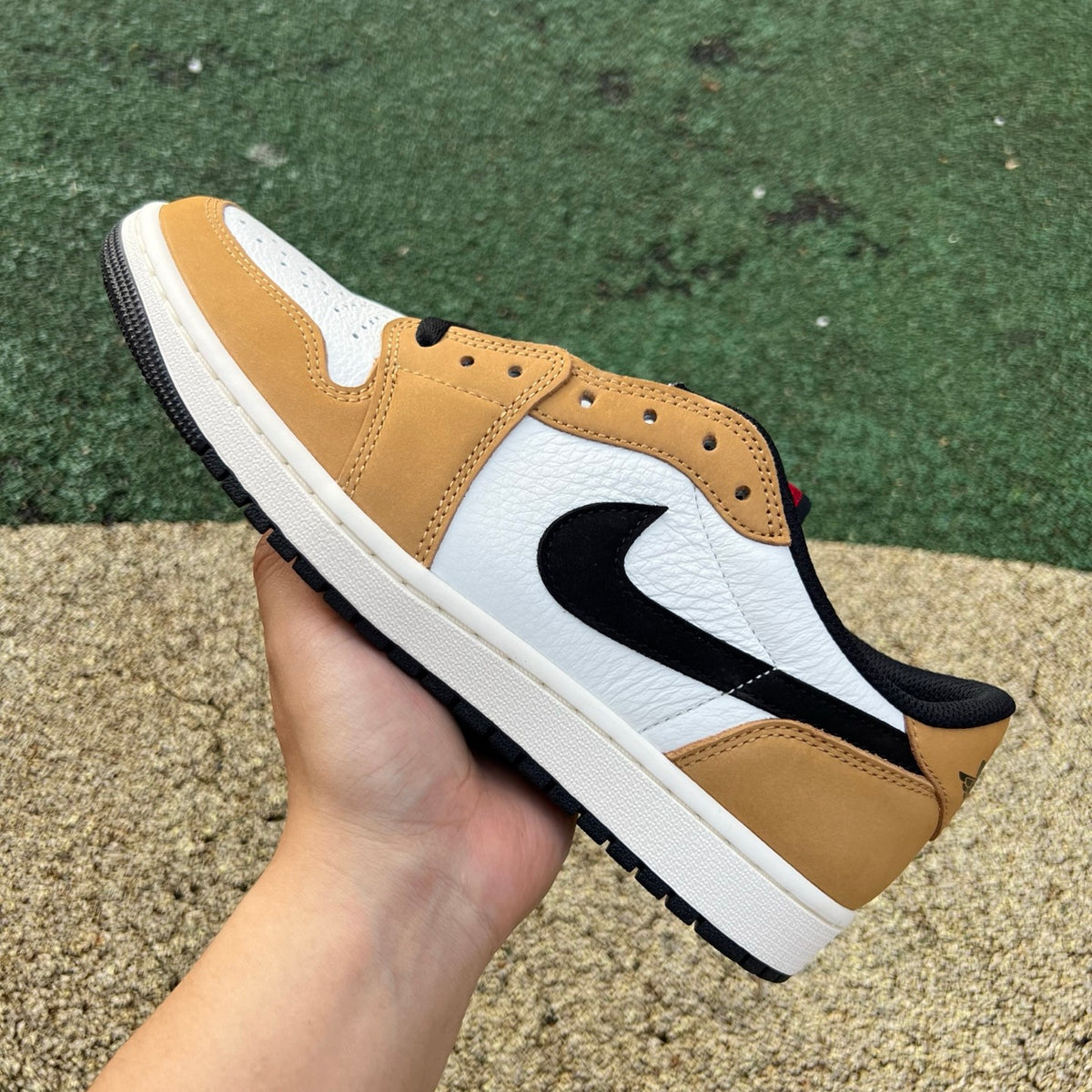 Nike Air Jordan 1 Low OG Rookie of the Year sneakers in white and black leather with Nike and Jordan branding.