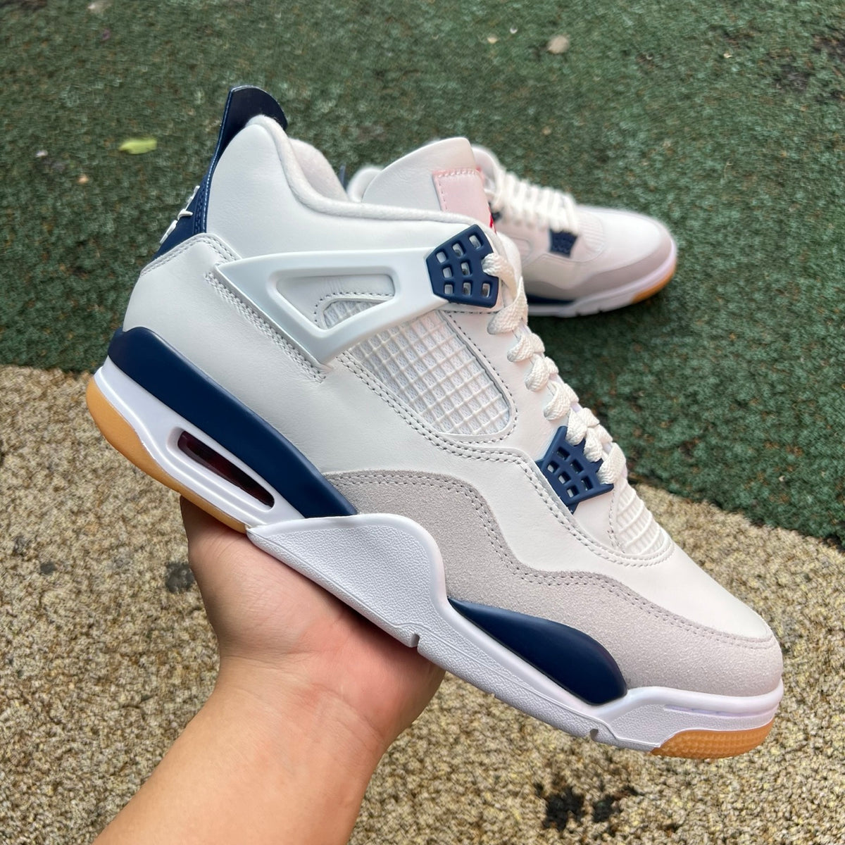 Nike Air Jordan 4 Retro SB sneakers in navy with white accents, featuring classic design and Nike x Jordan branding.