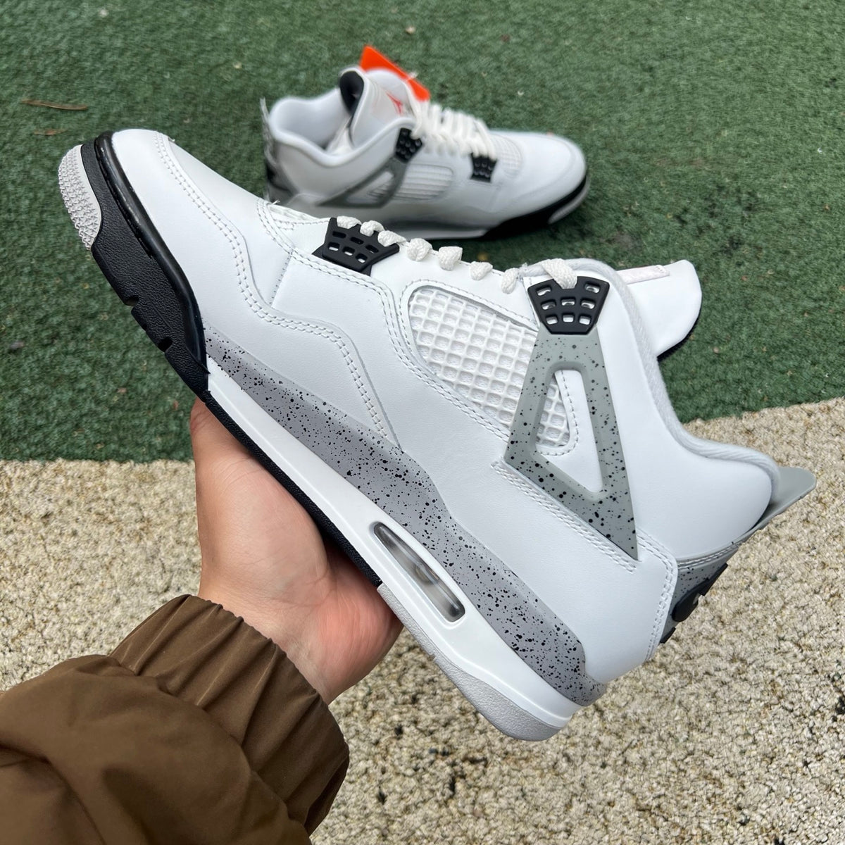 Nike Air Jordan 4 Retro White Cement sneakers from the Nike x Jordan collection, showcasing white and gray colorway and classic design.