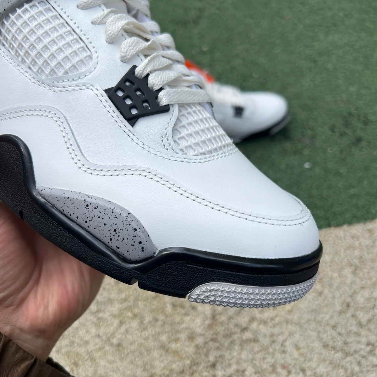 Nike Air Jordan 4 Retro White Cement sneakers in white with black accents, showcasing the classic design and premium materials.