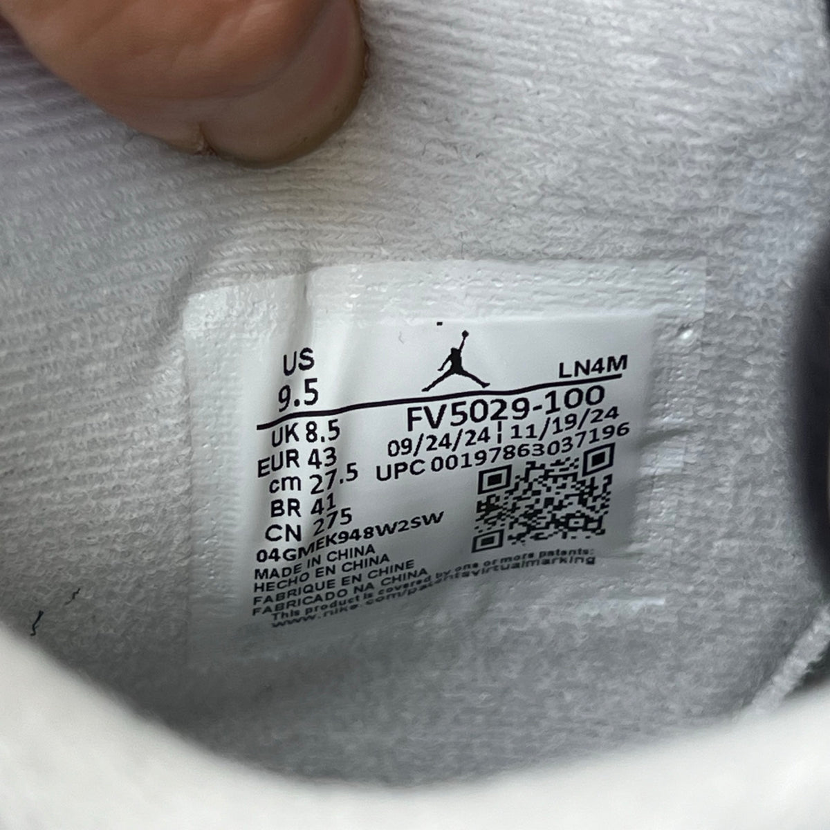Nike Air Jordan 4 Retro White Cement sneakers in white and gray with rubber soles, displayed on a plain background.