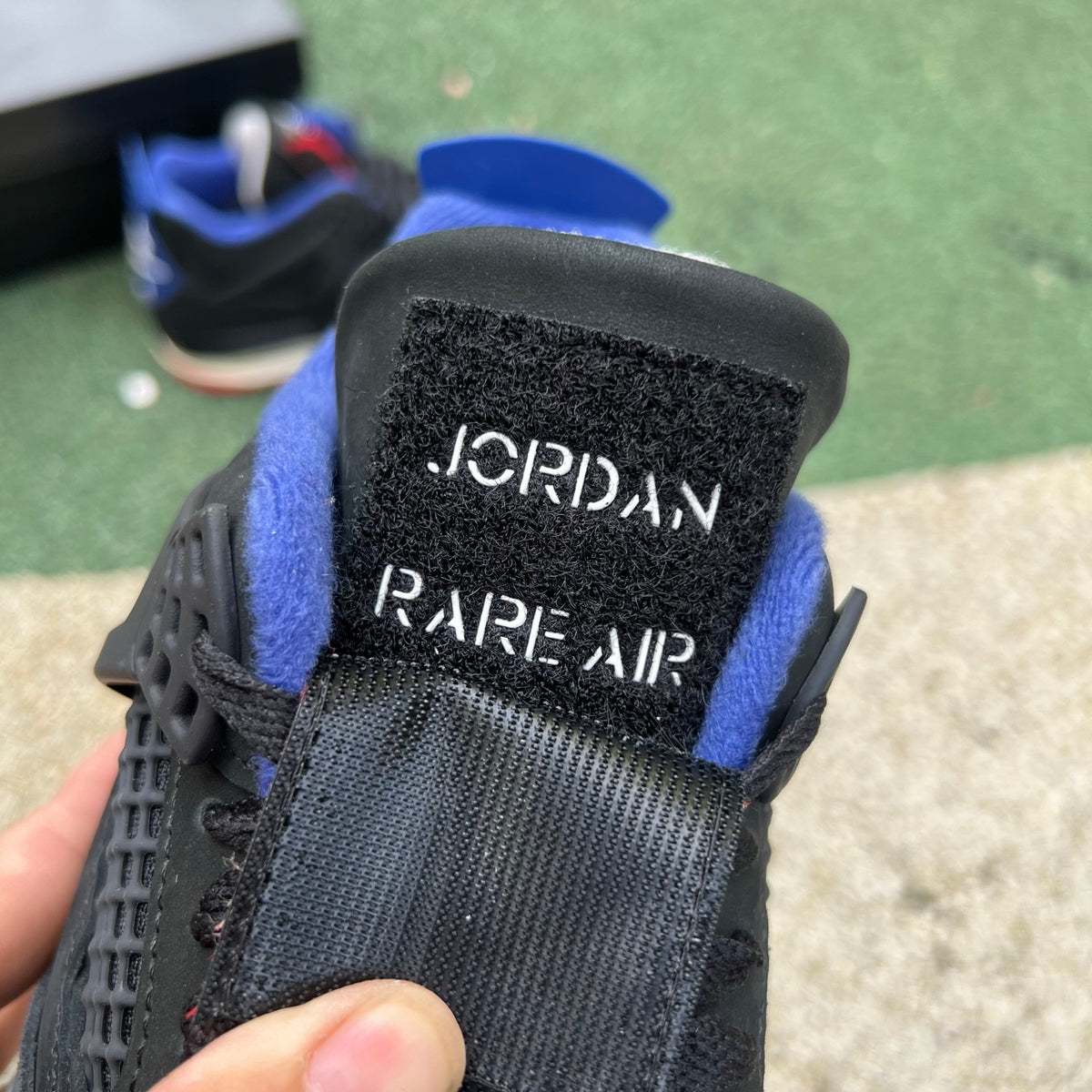 Nike Air Jordan 4 Retro Rare Air sneakers with white lettering, featuring white and gray colorway and classic design details.