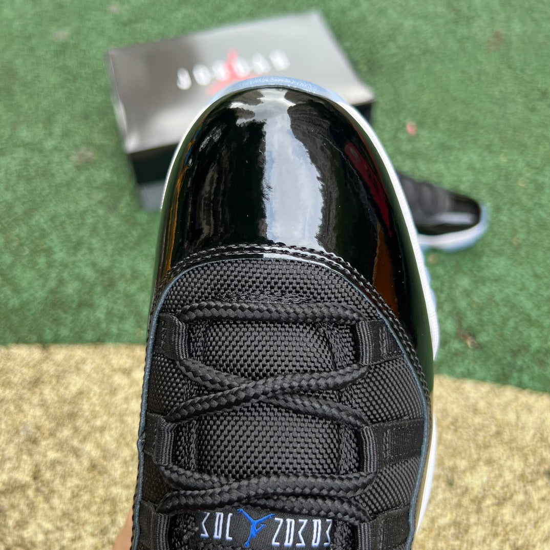 Nike Air Jordan 11 Retro Low Space Jam sneakers in black and blue with white accents, displayed on a plain background.