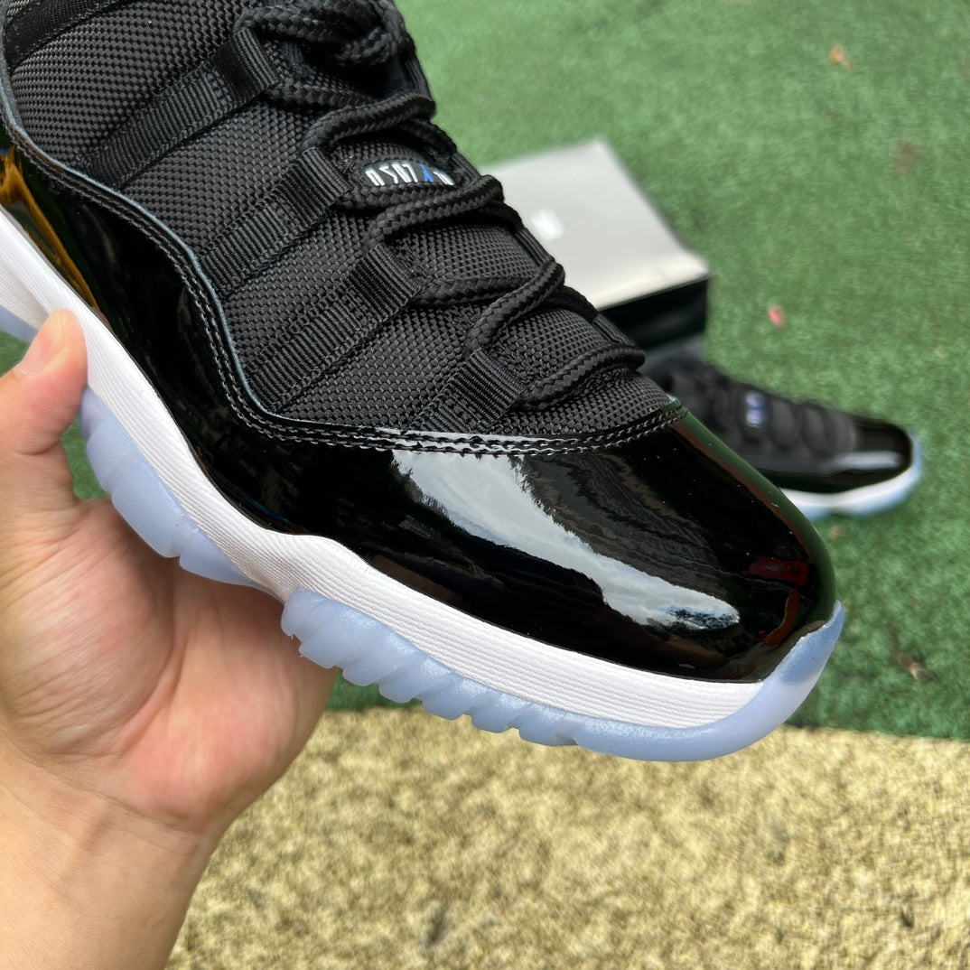 Nike Air Jordan 11 Retro Low Space Jam sneakers in black and blue with patent leather detailing, front view.