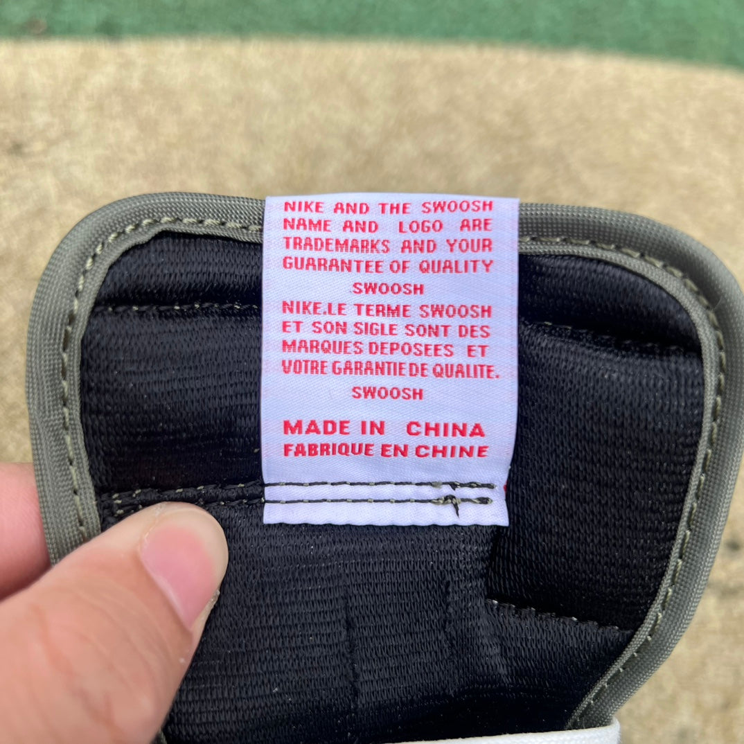 Nike Air Jordan 1 Retro Low OG SP Travis Scott sneakers in Medium Olive, showing the side view with branding and textured materials.