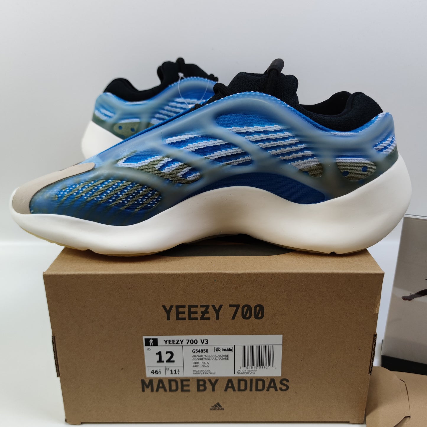 Adidas Originals Yeezy Boost 700 V3 Arzareth sneakers in gray with chunky design and boost sole, shown from side angle.