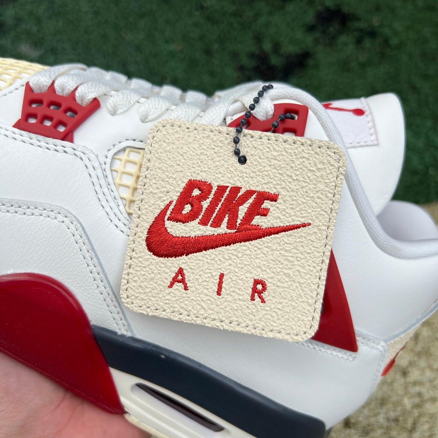 Nike Jordan 4 Retro OG Nigel Sylvester Brick sneakers in red and white, featuring classic design and premium materials.