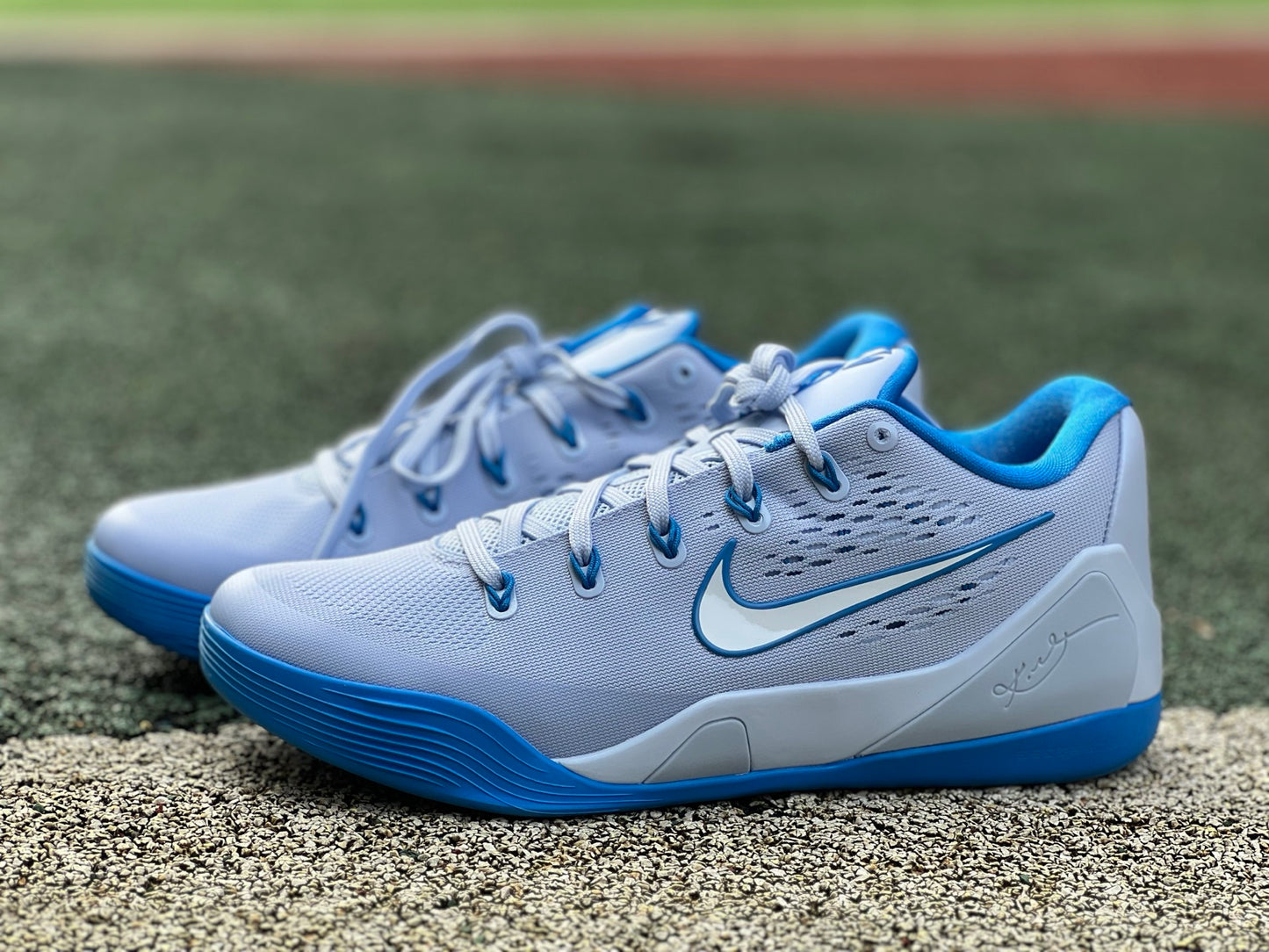 Nike Kobe 9 EM Low Protro basketball shoes in hydrogen blue with black accents, showcasing the athletic design and Nike branding.