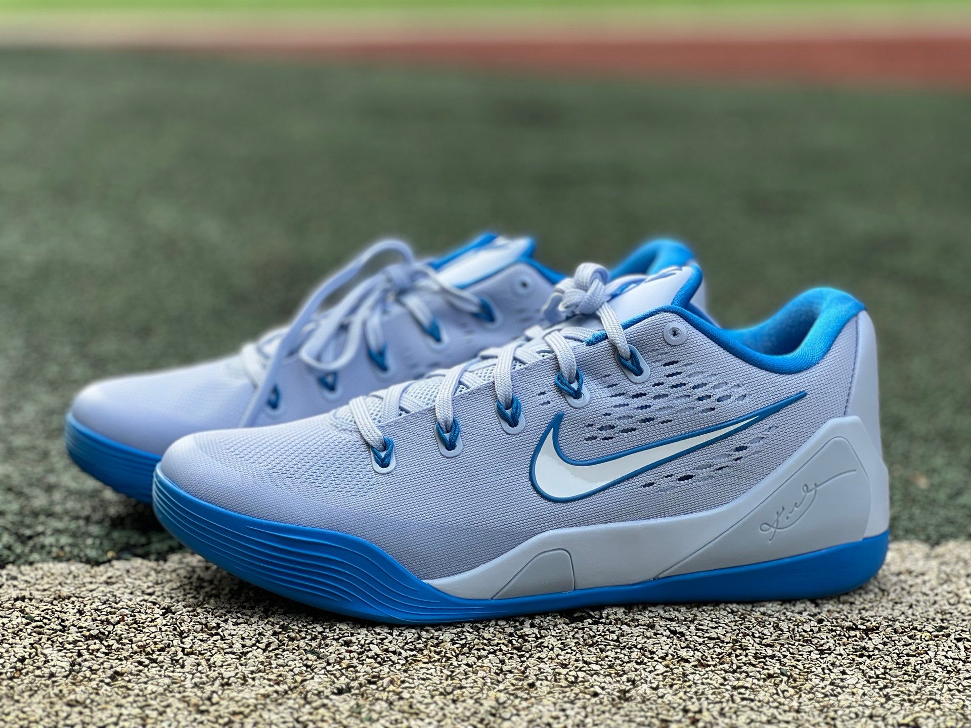 Nike Kobe 9 EM Low Protro basketball shoes in hydrogen blue with black accents, showcasing the athletic design and Nike branding.