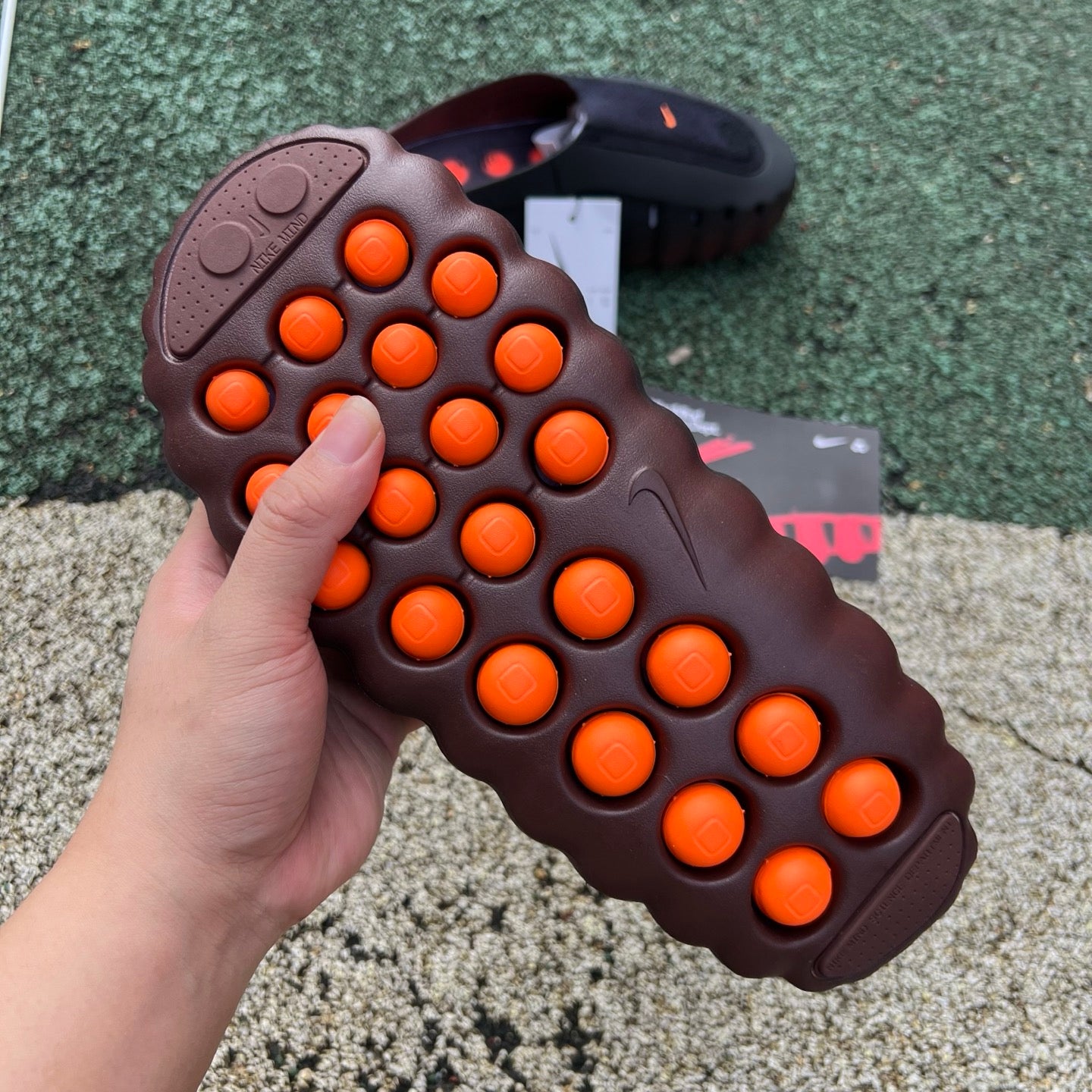 Nike x Jordan Mind 001 Flyknit Slide in bronze eclipse and total orange with Nike branding and sleek, comfortable design.