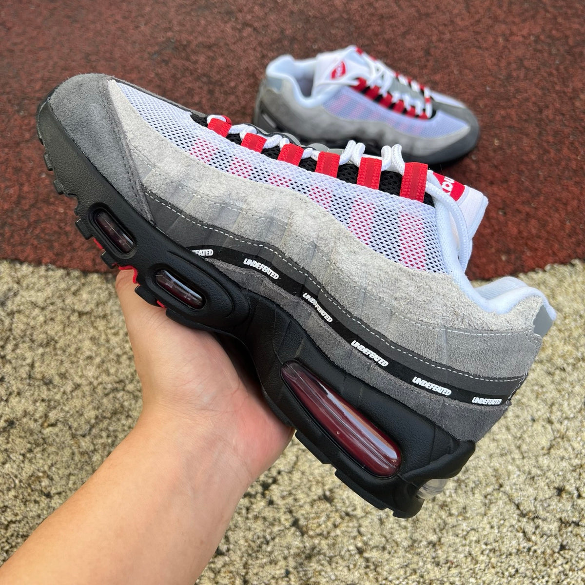 Nike Air Max 95 SP Undefeated Geo Tokyo Bright Crimson sneaker showing the vibrant red and black design with textured details.