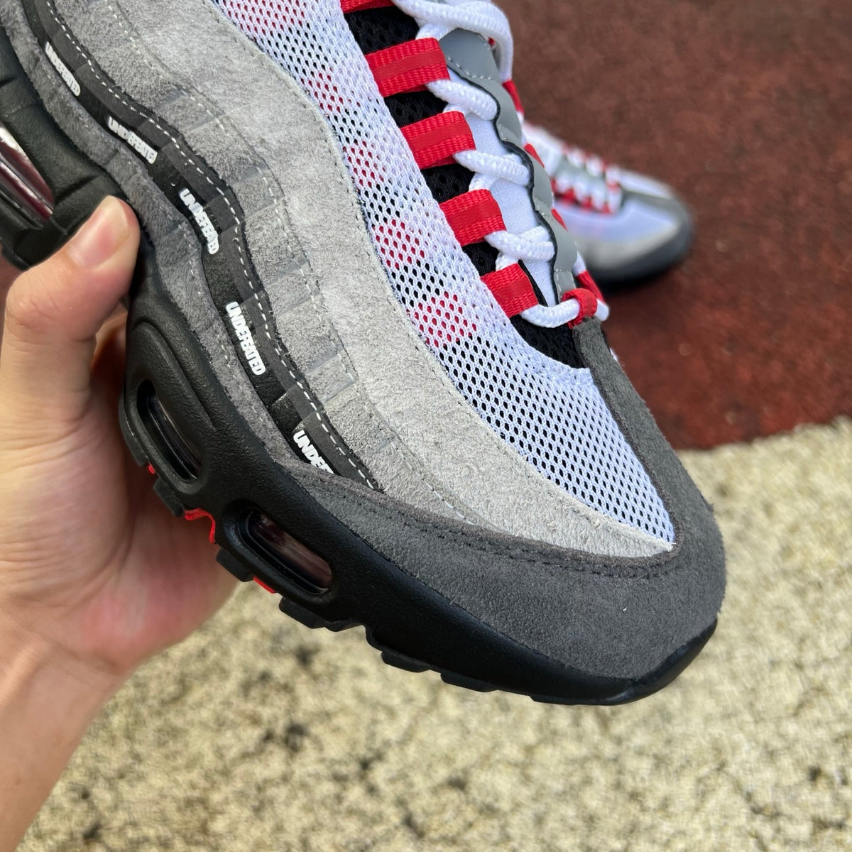 Nike Air Max 95 SP Undefeated Geo Tokyo sneakers in bright crimson with detailed design and branding, displayed on a white background.
