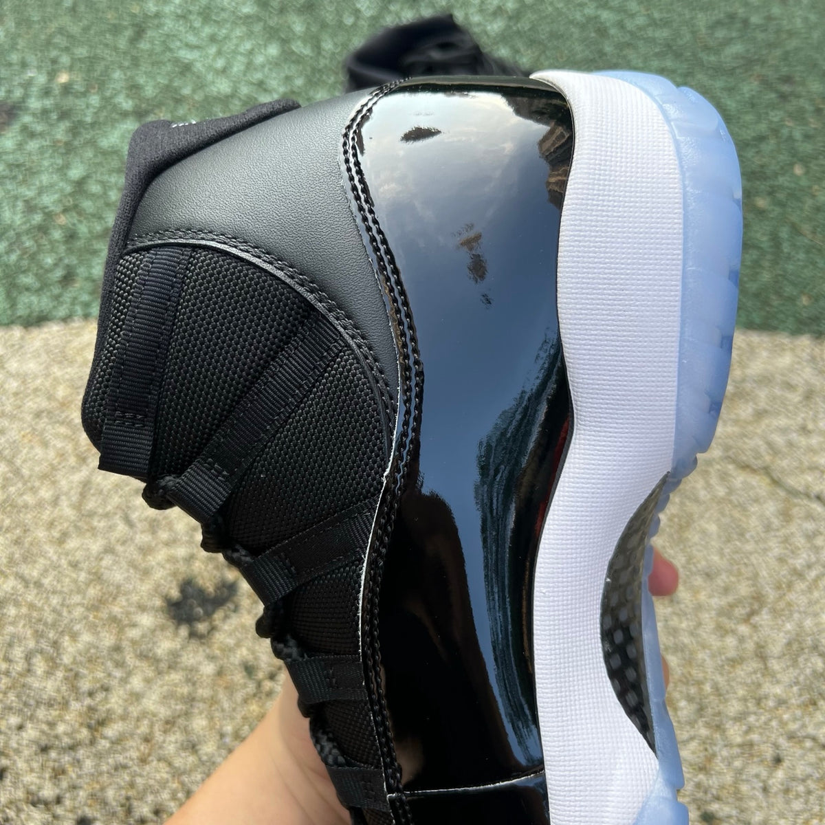 Nike Air Jordan 11 Retro Space Jam sneakers in black and blue with patent leather detailing, styled on a clean white background.
