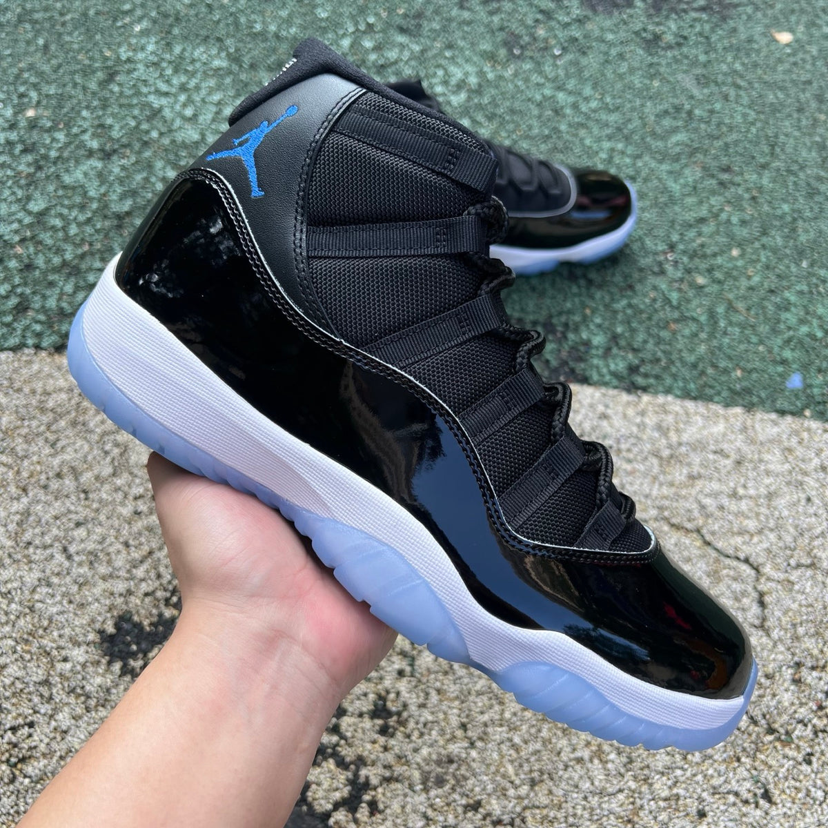 Nike Air Jordan 11 Retro Space Jam sneakers in black and blue with patent leather and Jumpman logo, front view.