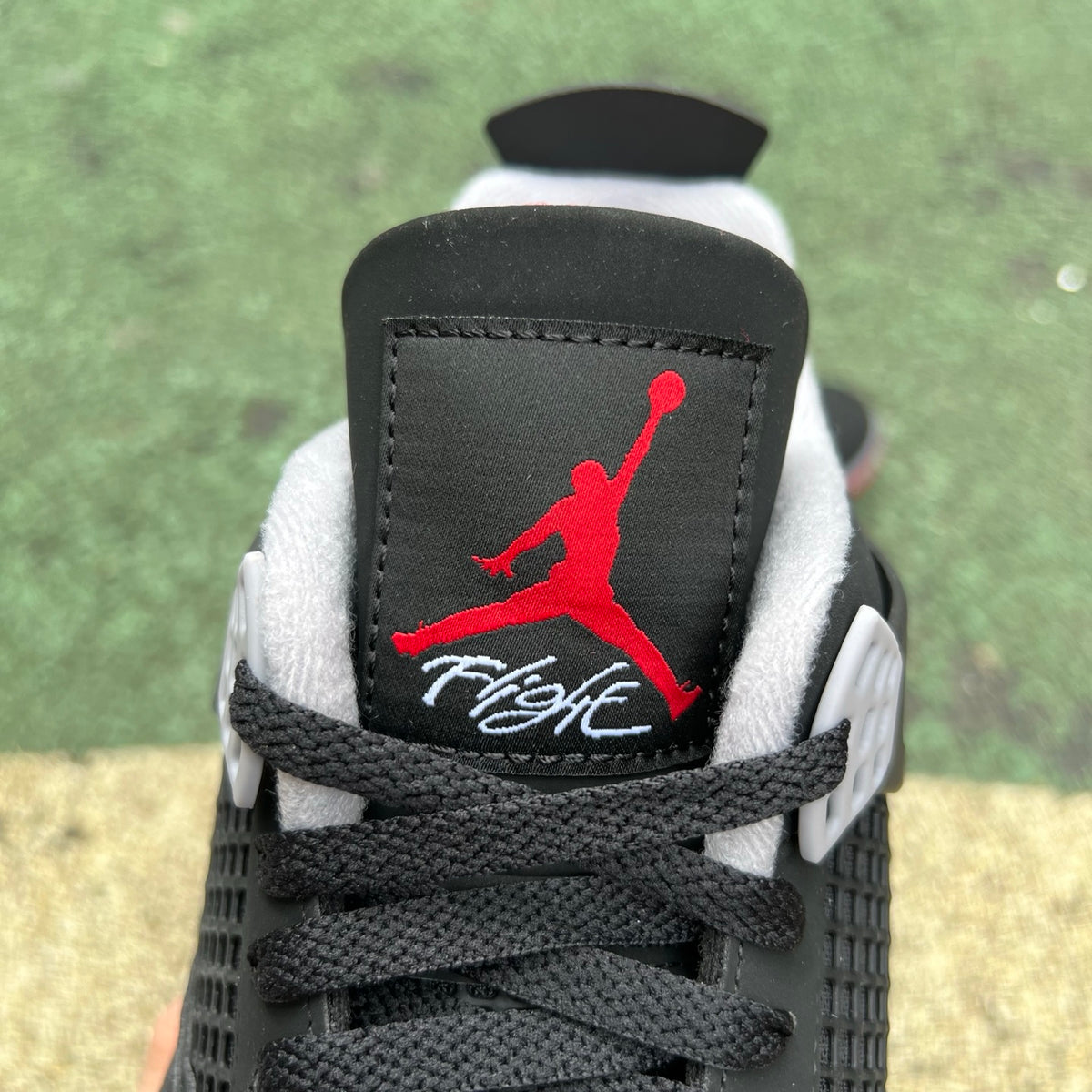 Nike Air Jordan 4 Retro OG Bred sneakers in black and red with white accents, displayed on a plain background.