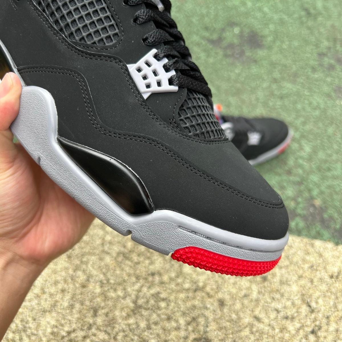 Nike Air Jordan 4 Retro OG Bred sneakers in black and red with white accents, showcasing the classic Jordan design.