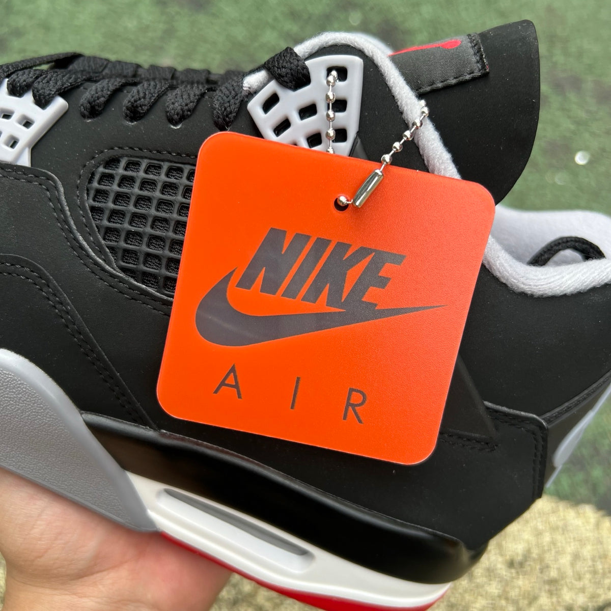 Nike Air Jordan 4 Retro OG Bred sneakers in black and red with white accents, featuring signature design and branding details.