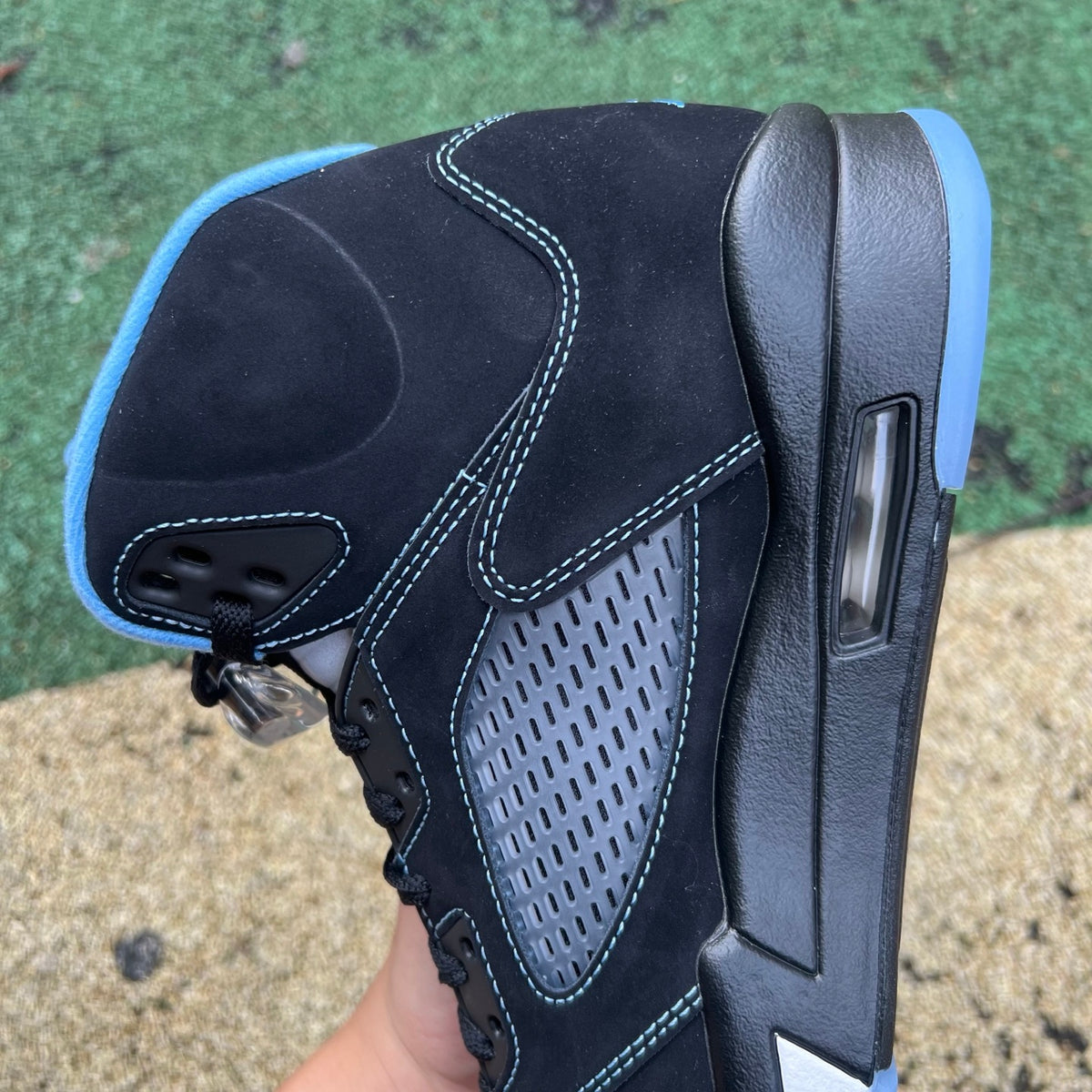 Nike Air Jordan 5 Retro sneakers in black and university blue, featuring a sleek design and iconic style.