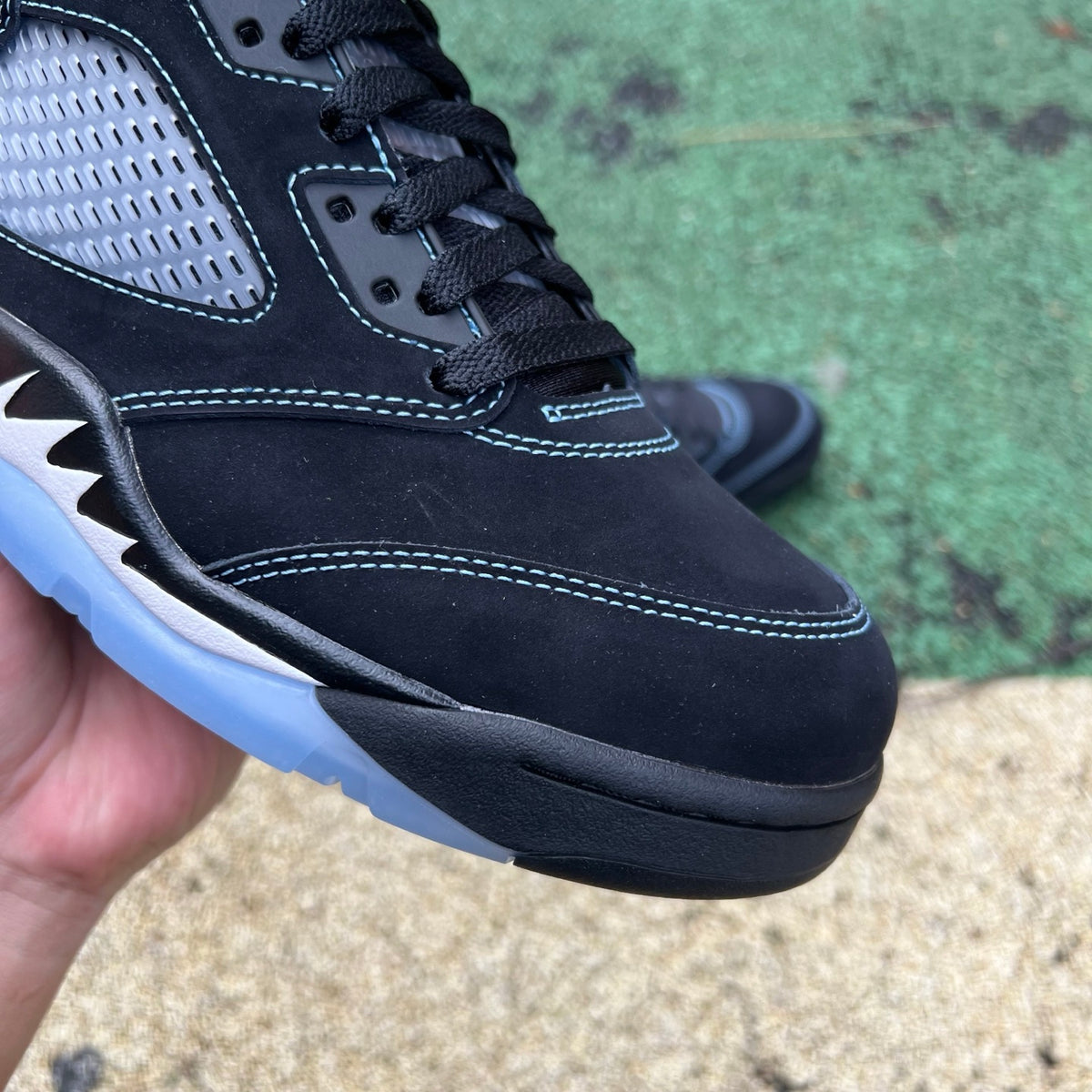Nike Air Jordan 5 Retro sneakers in black and university blue, showcasing the classic design and color details.