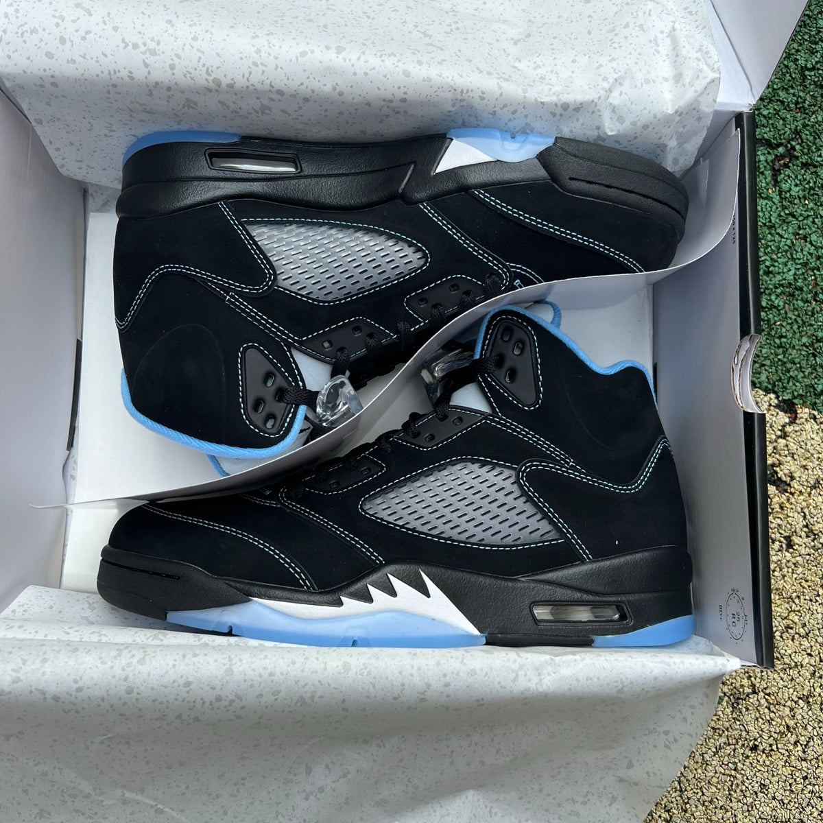 Nike Air Jordan 5 Retro sneakers in black with university blue accents, featuring a classic design and visible Nike Jordan branding.