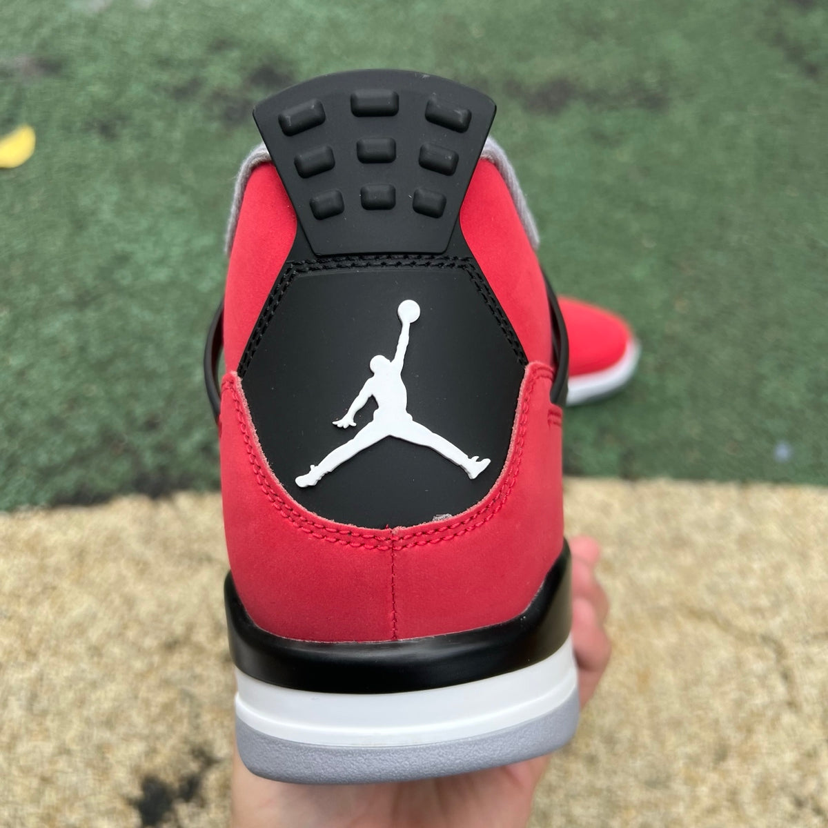 Nike Air Jordan 4 Retro Toro Bravo sneakers in red and black, featuring classic design and signature Nike Jordan branding.