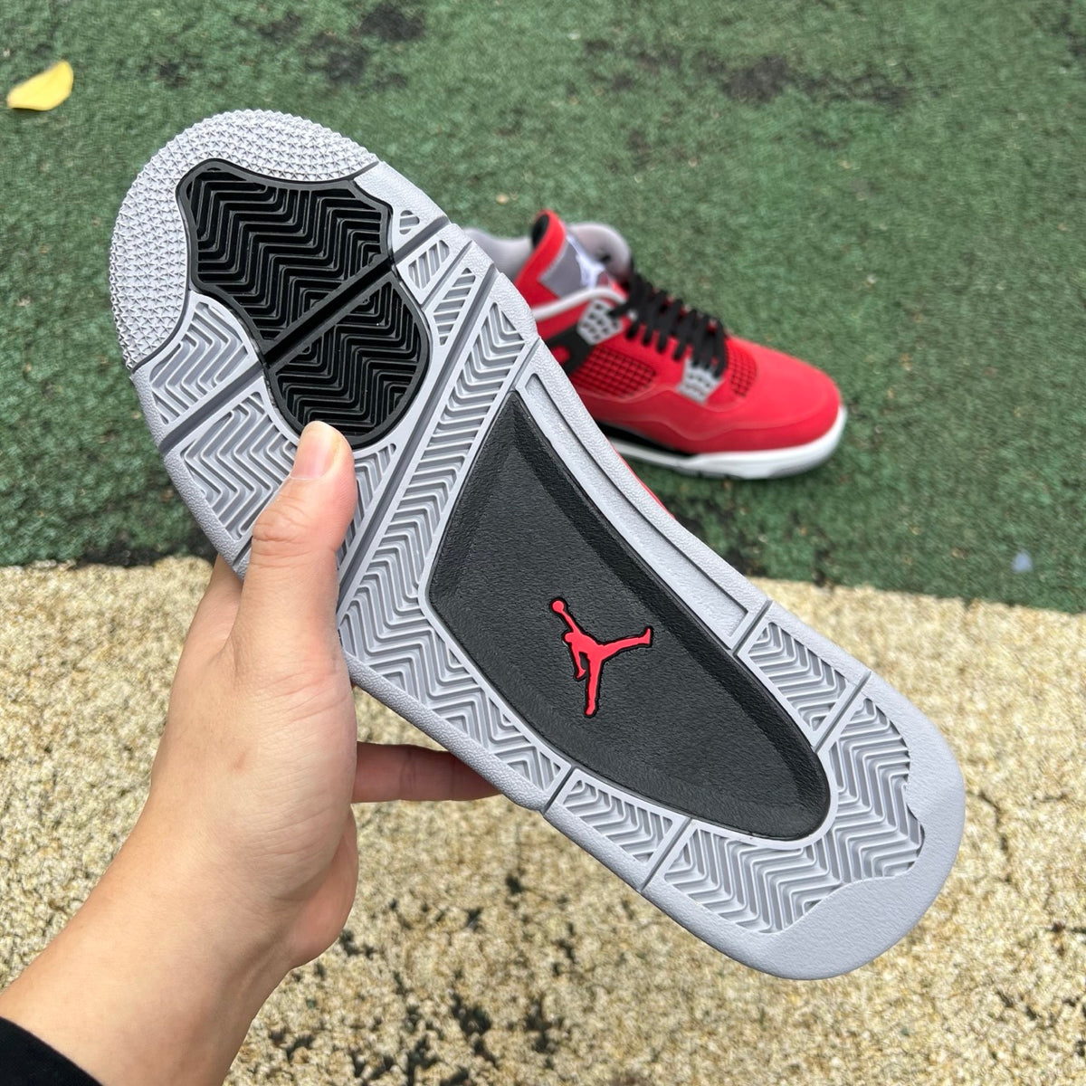 Nike Air Jordan 4 Retro Toro Bravo sneakers in red and black leather, showcasing the iconic design and branding details.