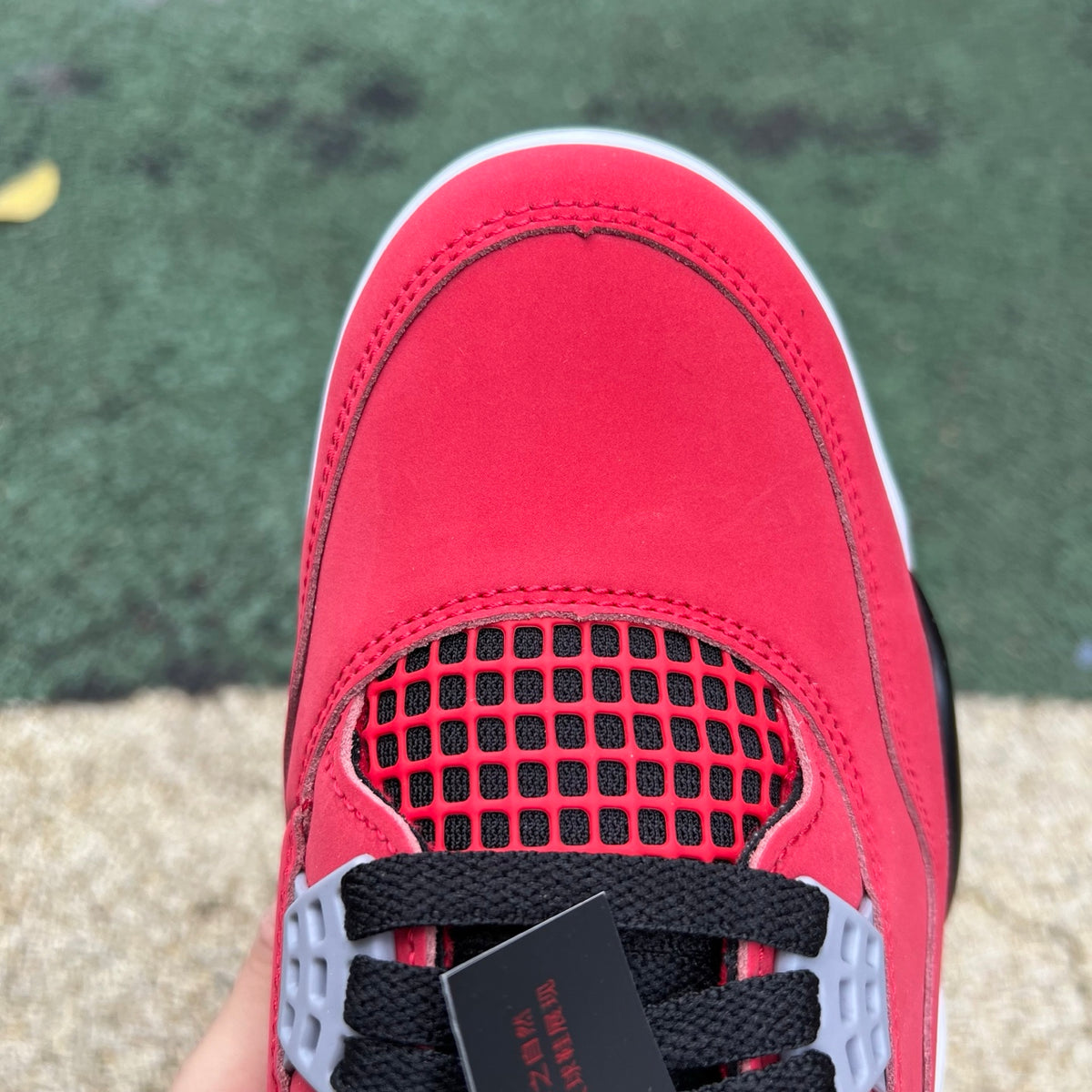 Nike Air Jordan 4 Retro Toro Bravo sneakers in red and black with white accents, showcasing the iconic basketball shoe design.