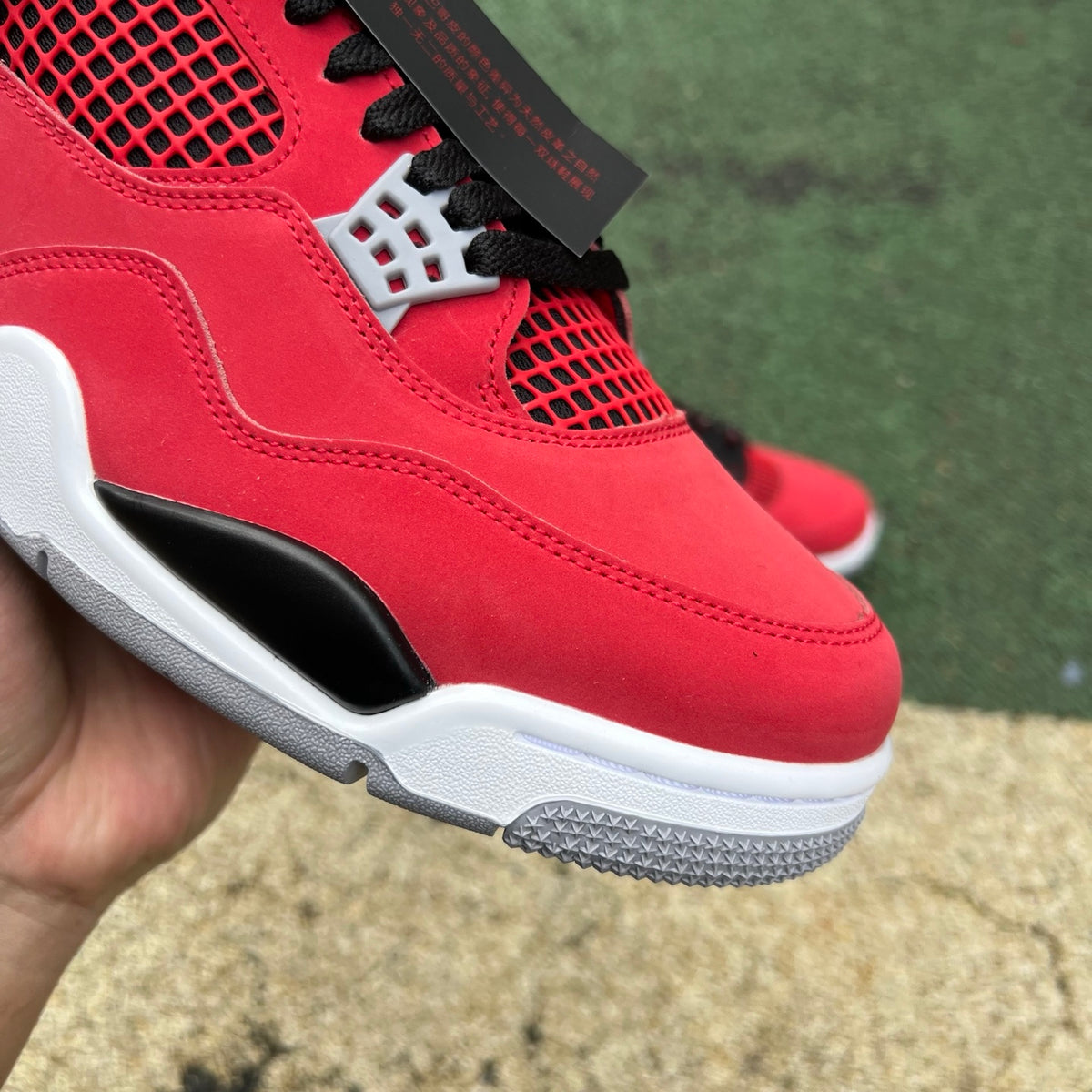 Nike Air Jordan 4 Retro Toro Bravo sneakers in red and black, featuring Nike and Jordan branding, displayed on a neutral background.