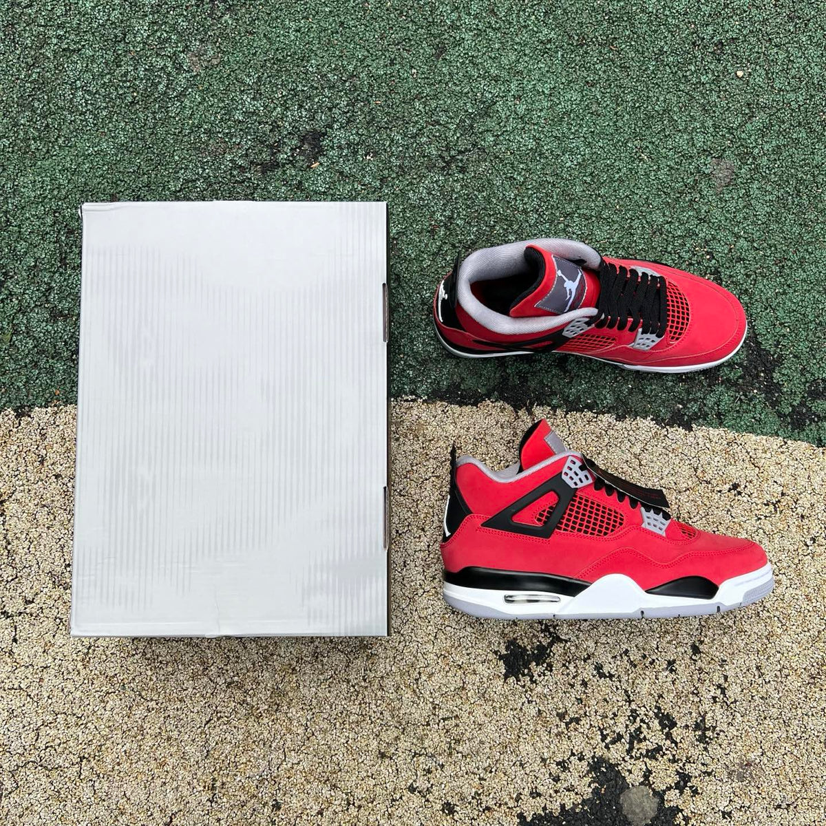 Nike Air Jordan 4 Retro Toro Bravo sneakers in red and black leather with white accents, showing the side view and signature design details.