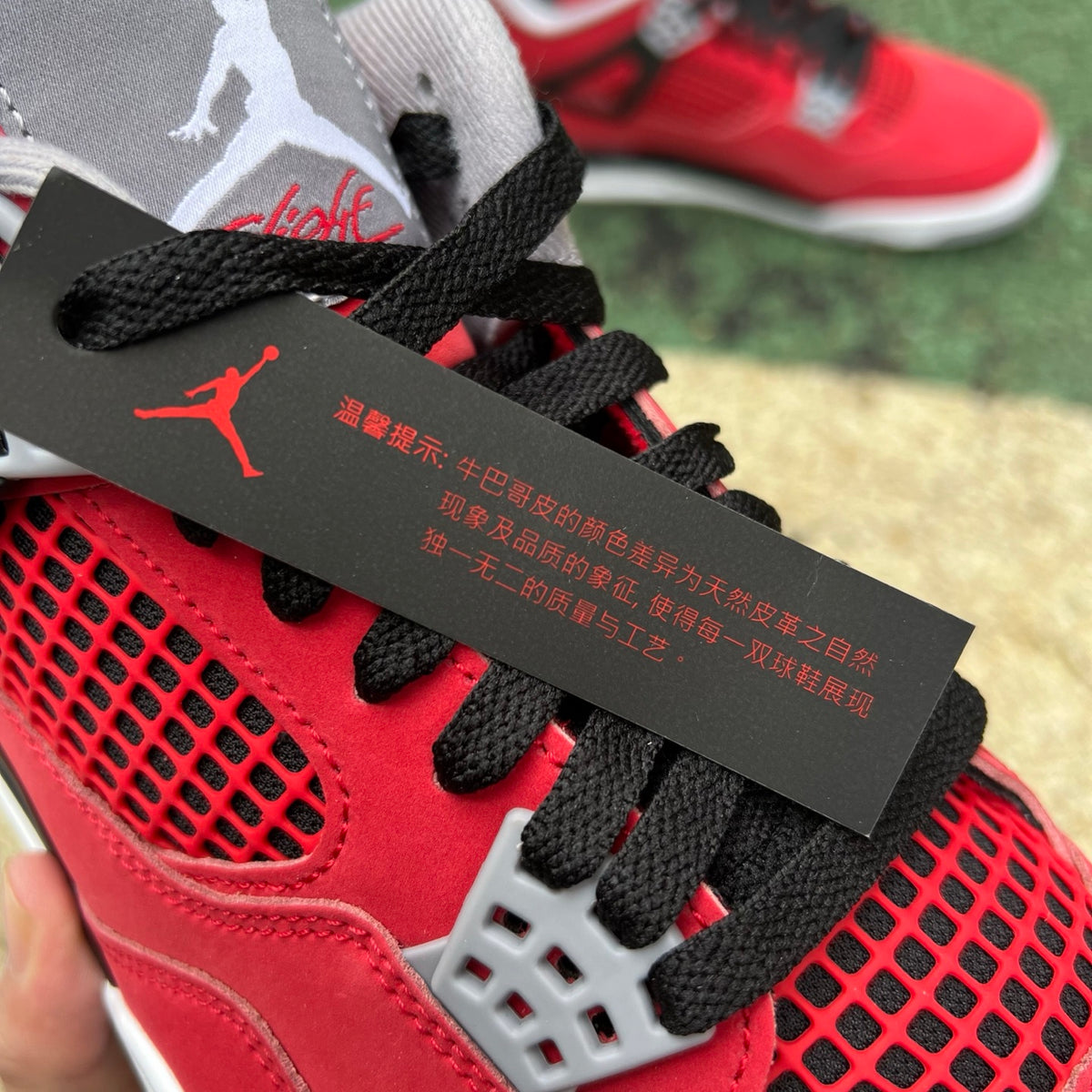 Nike Air Jordan 4 Retro Toro Bravo sneakers in red and black leather with white accents, showcasing the iconic design.