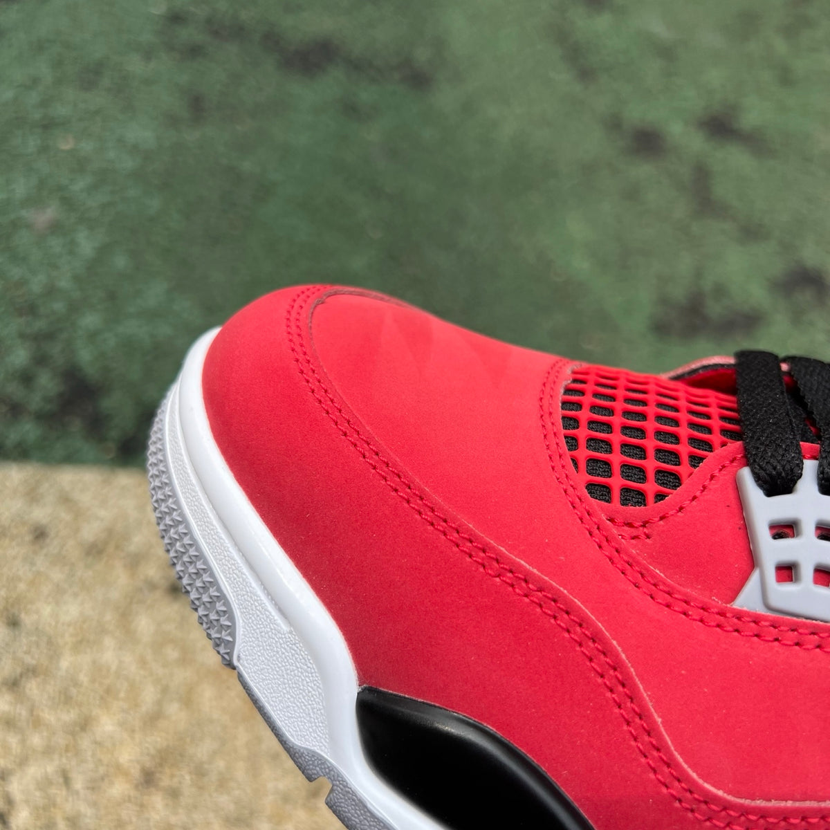 Nike Air Jordan 4 Retro Toro Bravo sneakers in red and black, featuring classic design and signature Jordan branding.