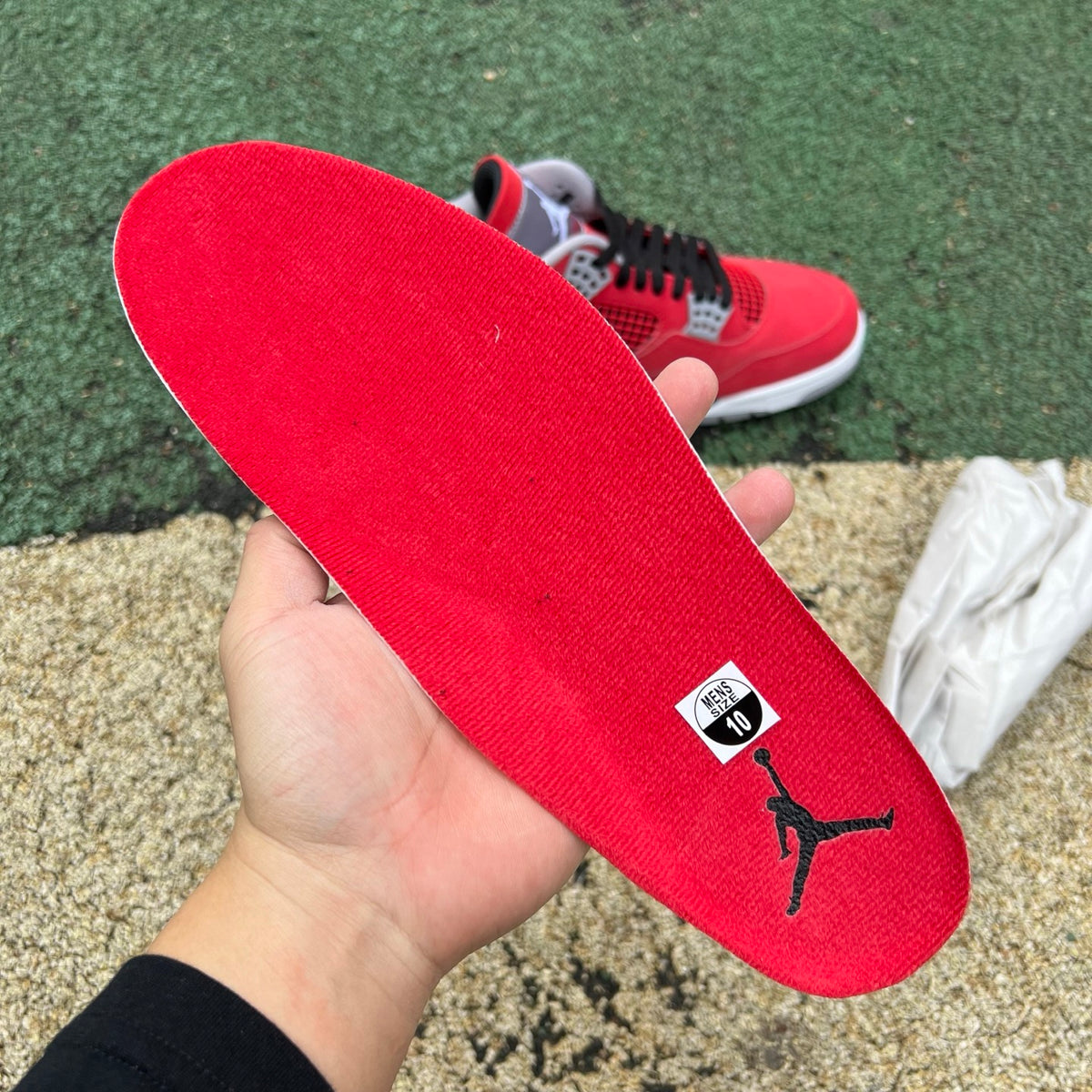 Nike Air Jordan 4 Retro Toro Bravo sneakers in red and black with white accents, featuring classic design and textured materials.